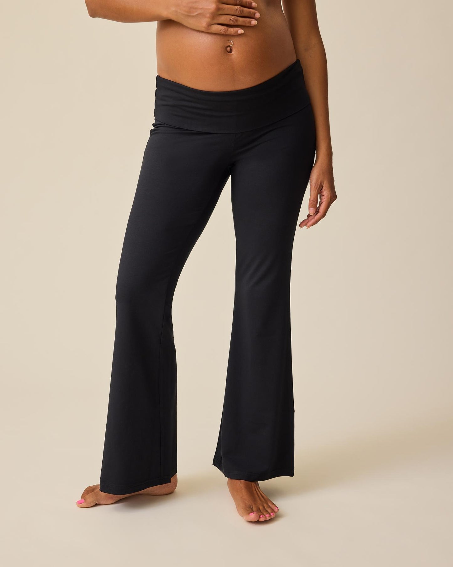 Front view of model wearing Bamboo Flex Maternity & Postpartum Flare Pant in Black on a beige background. @model_info:Hayley is 5'7" and wearing a Small.
