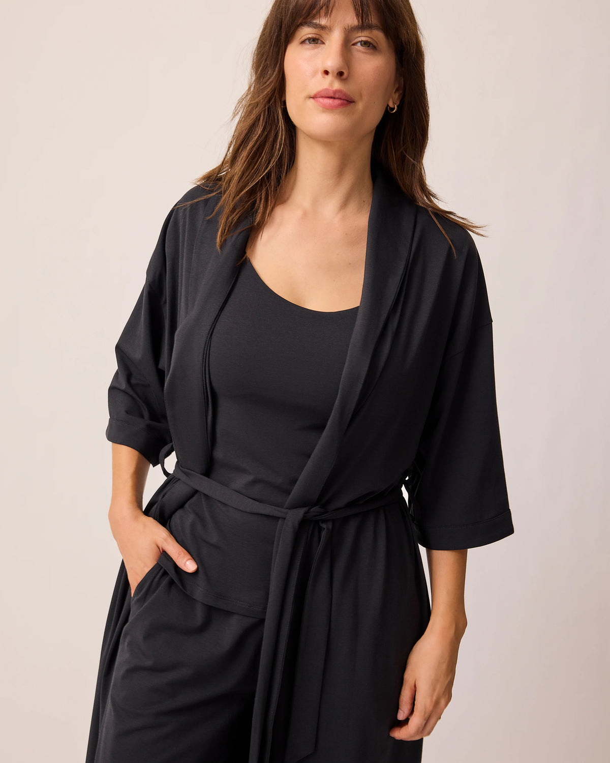 Model is wearing Robe slightly opened of the Maternity & Nursing Three-Piece Pajama Set in Black, on a beige background.