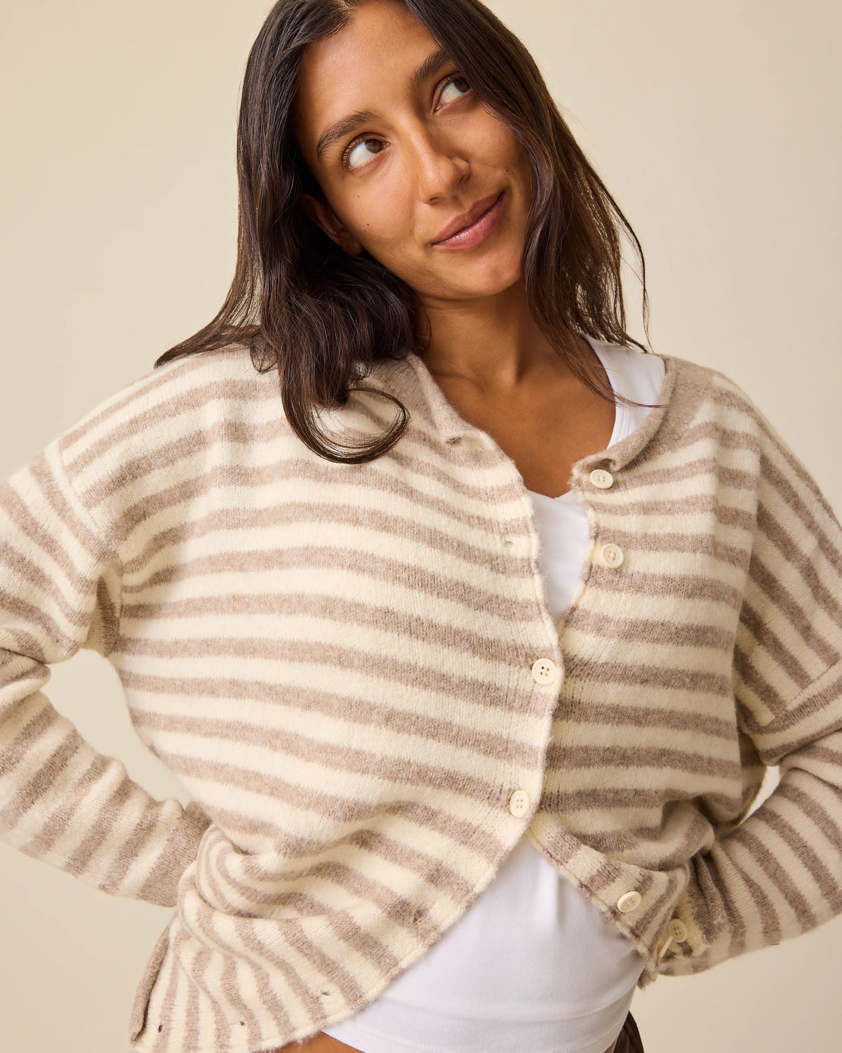 Model is wearing Ultra Soft Maternity & Postpartum Cardigan in Tan & White Stripe, Maternity & Postpartum Wide Leg Trouser in Brown and a nursing white tank, on a beige background.