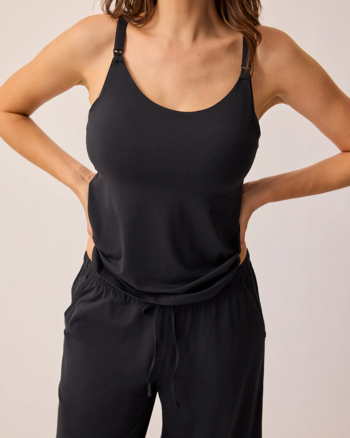 Model is wearing just the tank and pant of the Maternity & Nursing Three-Piece Pajama Set in Black, on a beige background.