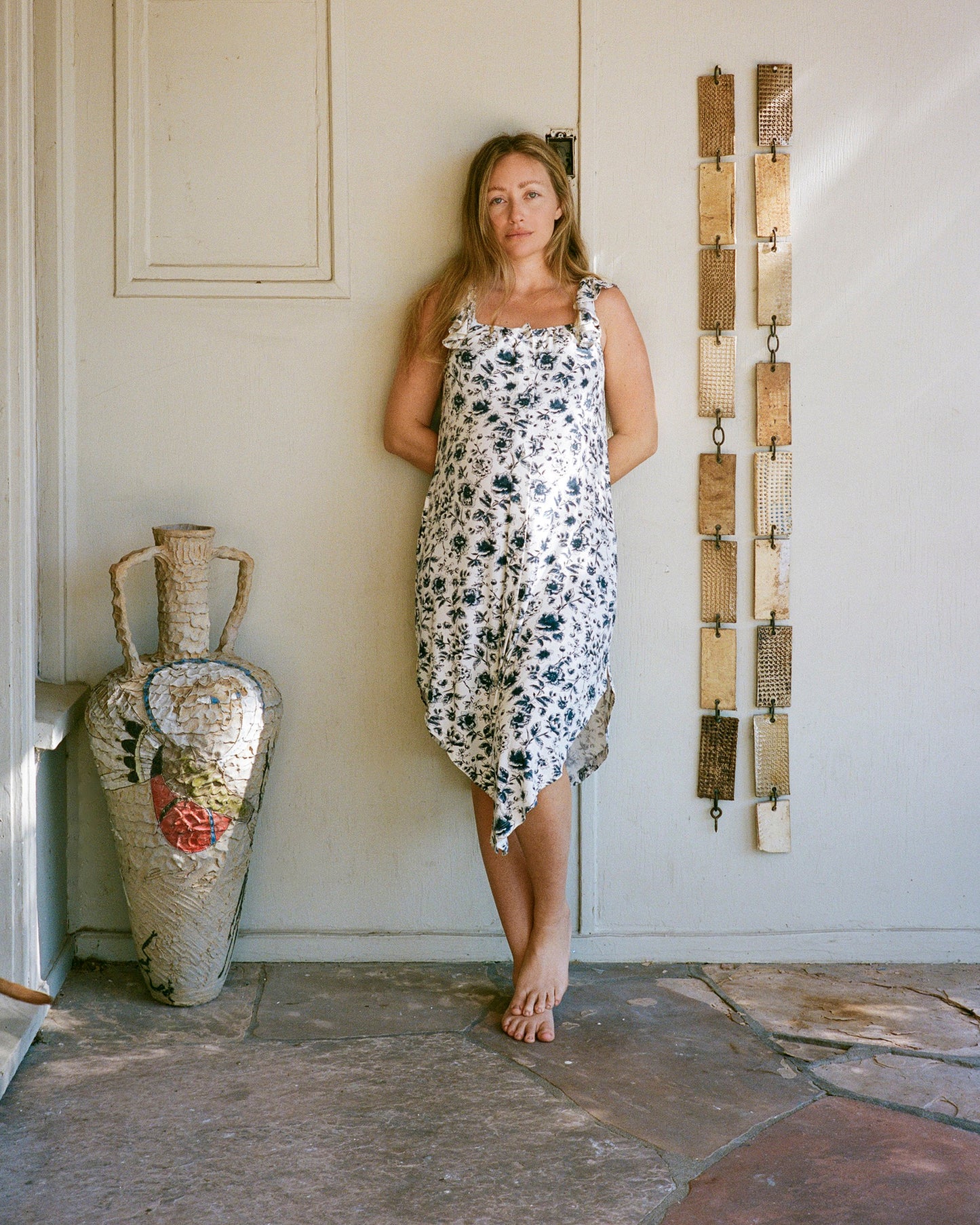 Model wearing Ruffle Strap Labor & Delivery Gown in Navy Toile on outdoor background in a courtyard with sculptures and artwork @model_info:Kate is 5'7" and wearing an XS/S.