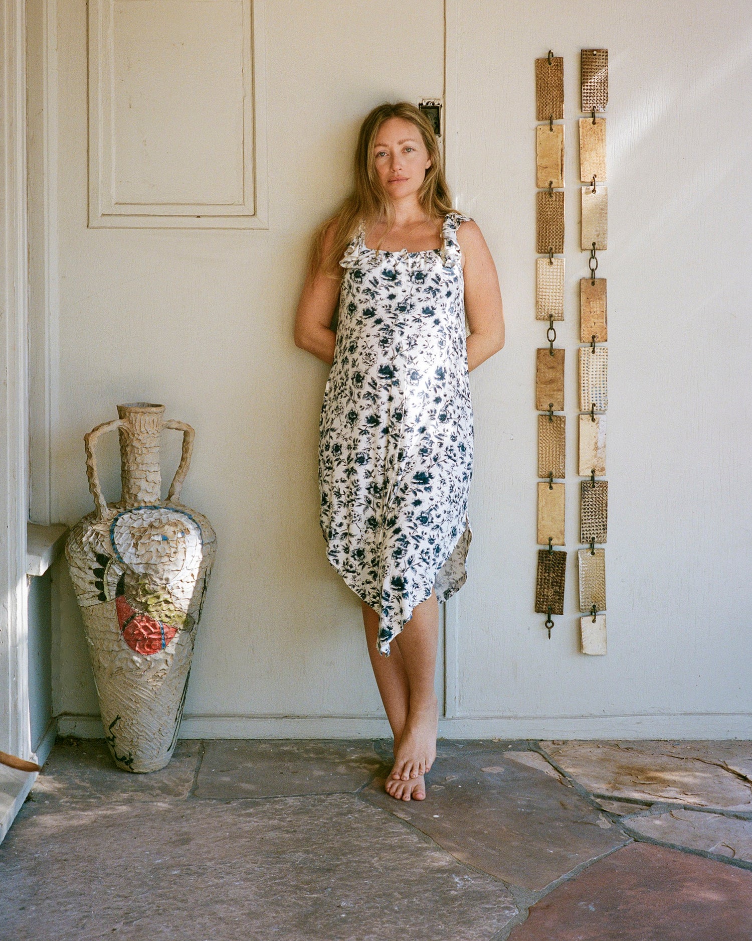 Model wearing Ruffle Strap Labor & Delivery Gown in Navy Toile on outdoor background in a courtyard with sculptures and artwork @model_info:Kate is 5'7" and wearing an XS/S.