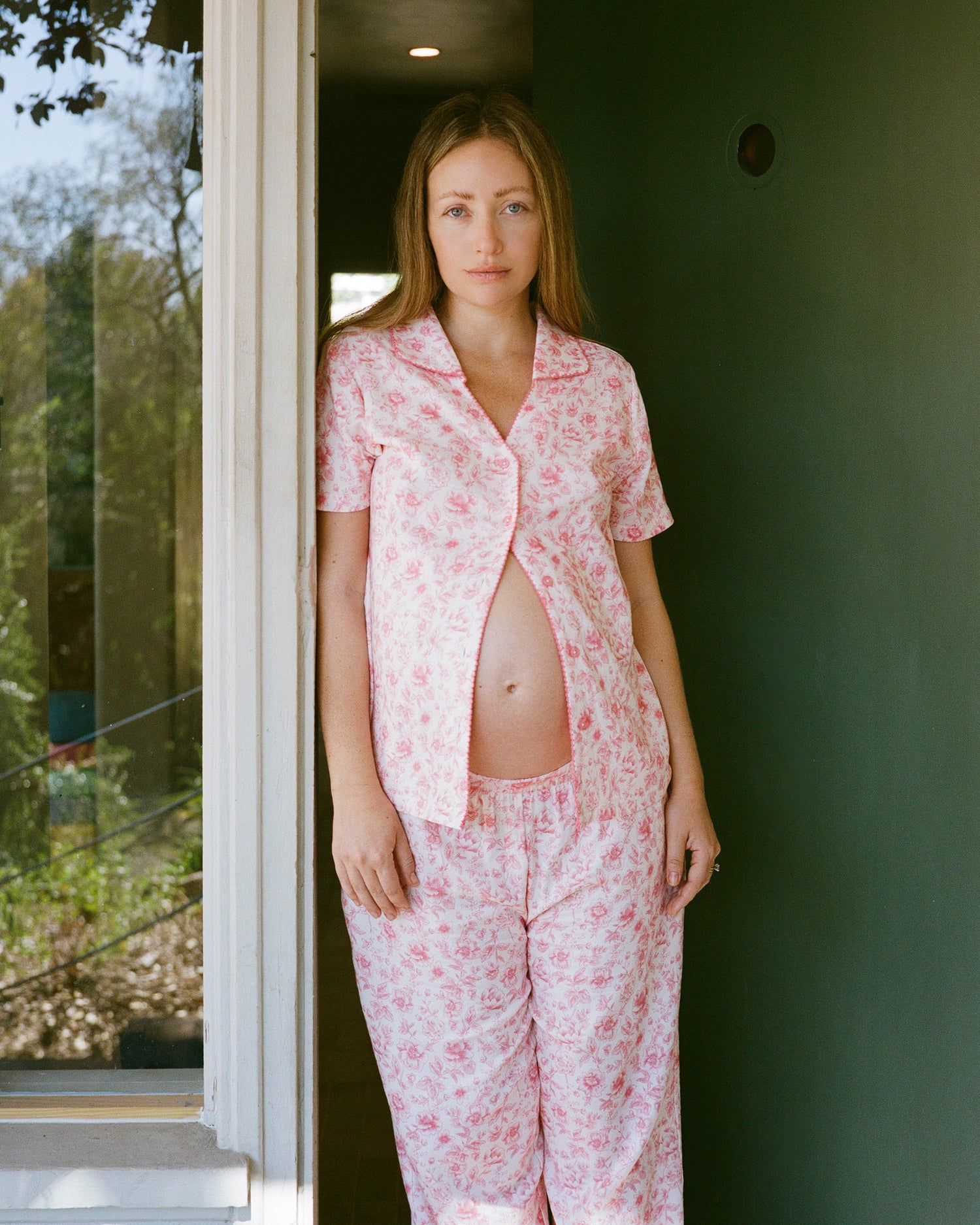Model wearing Cotton Bamboo Pajama Set in Pink Toile while standing in doorway, displaying baby bump. @model_info:Kate is 5'7" and wearing a Small.