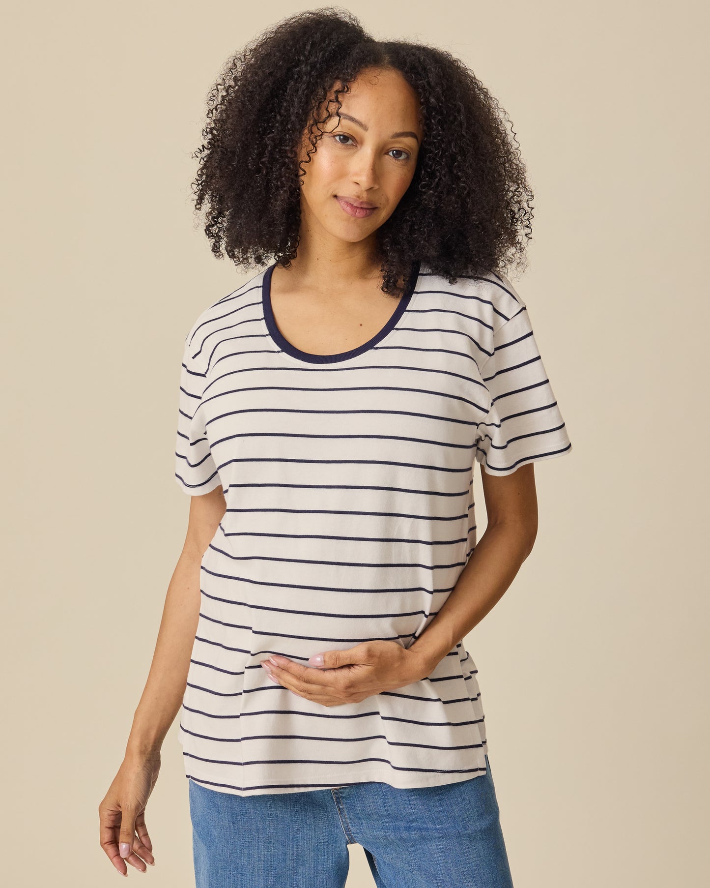 Model is wearing Relaxed Cotton Maternity & Nursing T-shirt in Navy & White Stripe on a beige background. @model_info:Courtney is wearing a Small.