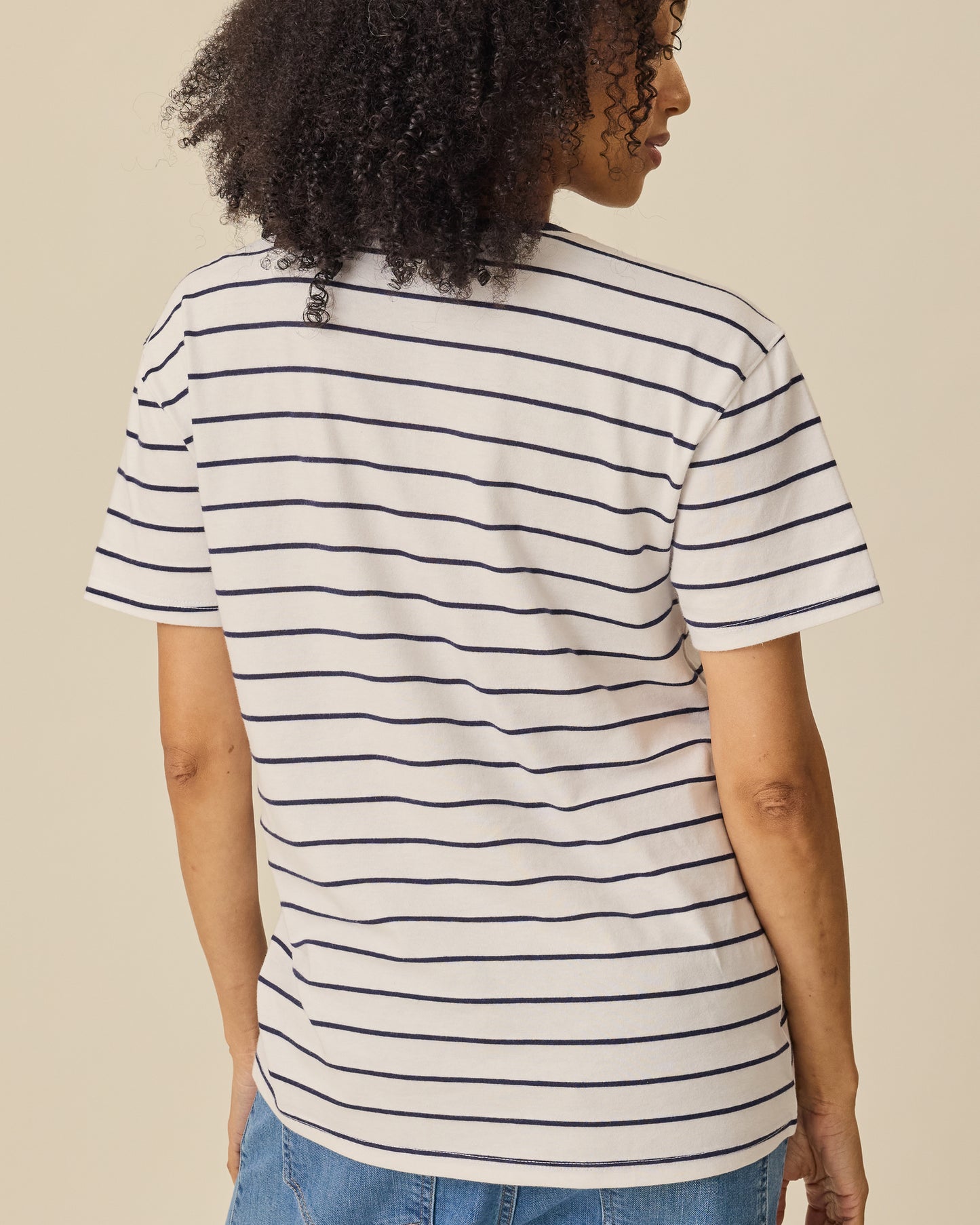 Back view of the Relaxed Cotton Maternity & Nursing T-shirt in Navy & White Stripe on a beige background. 
