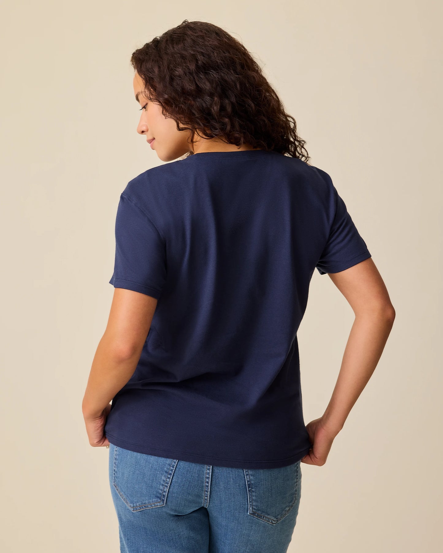 Back view of model wearing Relaxed Cotton Maternity & Nursing T-shirt in Navy on a beige background.