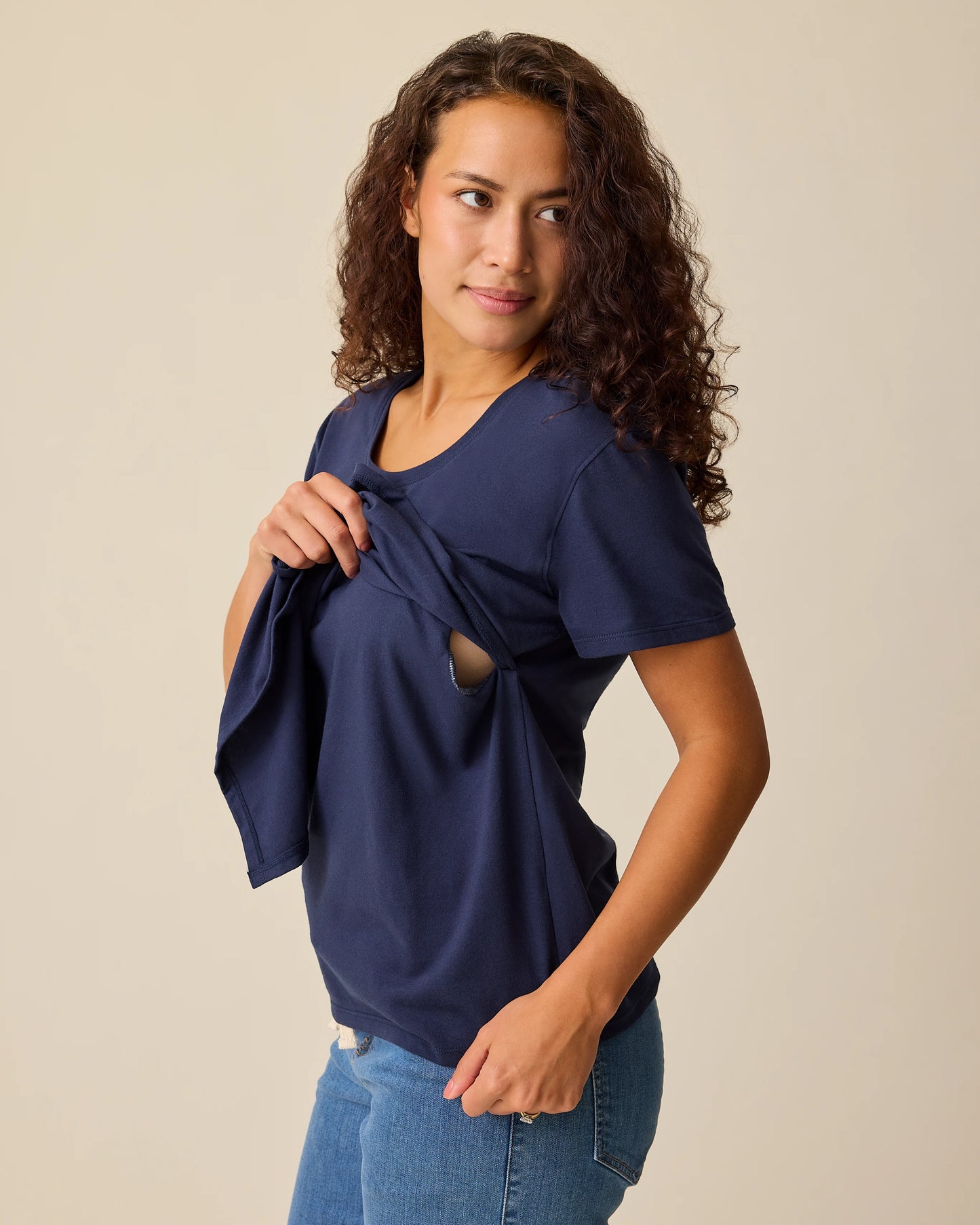 Side view of model displaying nursing access on the Relaxed Cotton Maternity & Nursing T-shirt in Navy on a beige background.