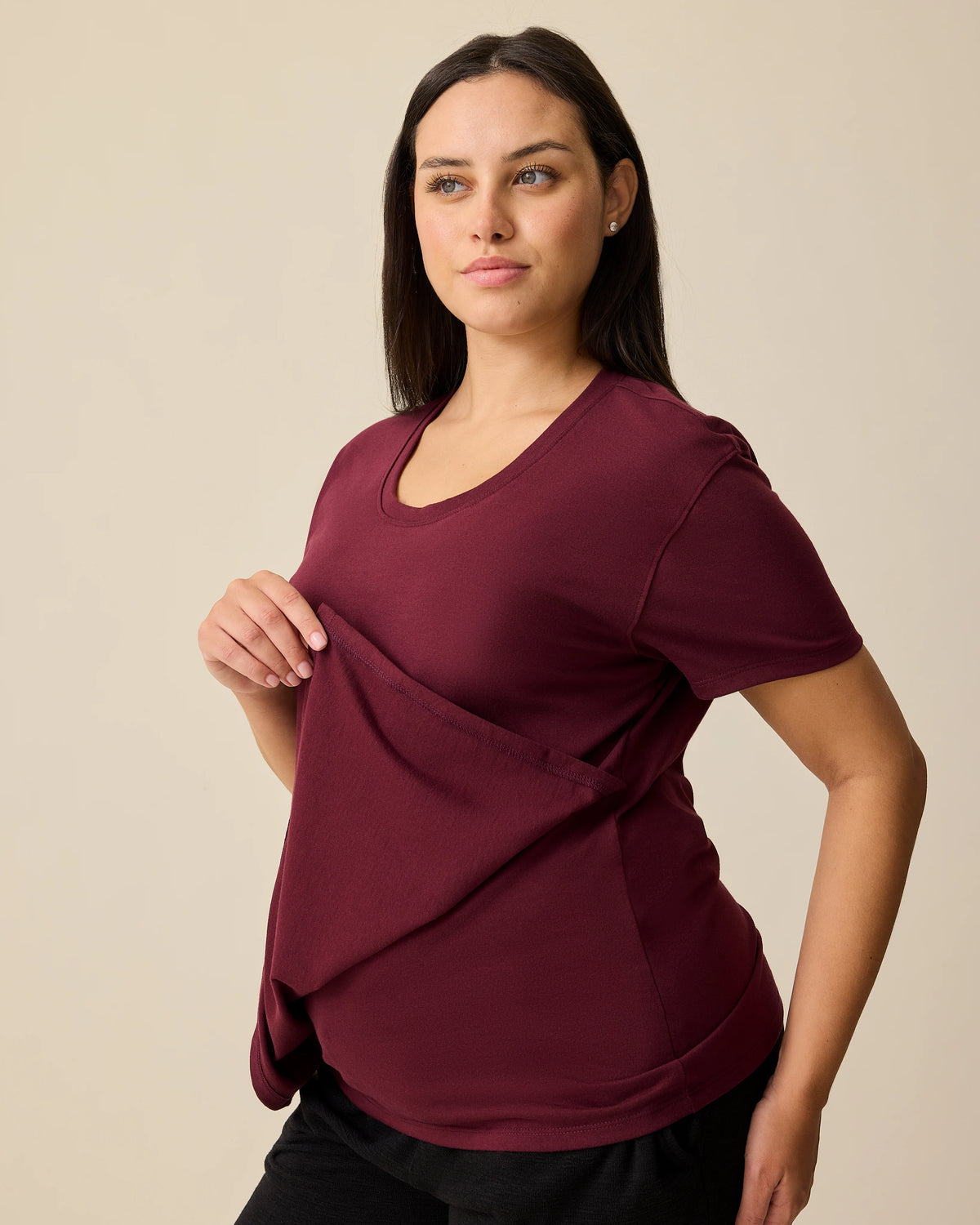 Side view of model displaying nursing access on the Relaxed Cotton Maternity & Nursing T-shirt in Fig on a beige background. 