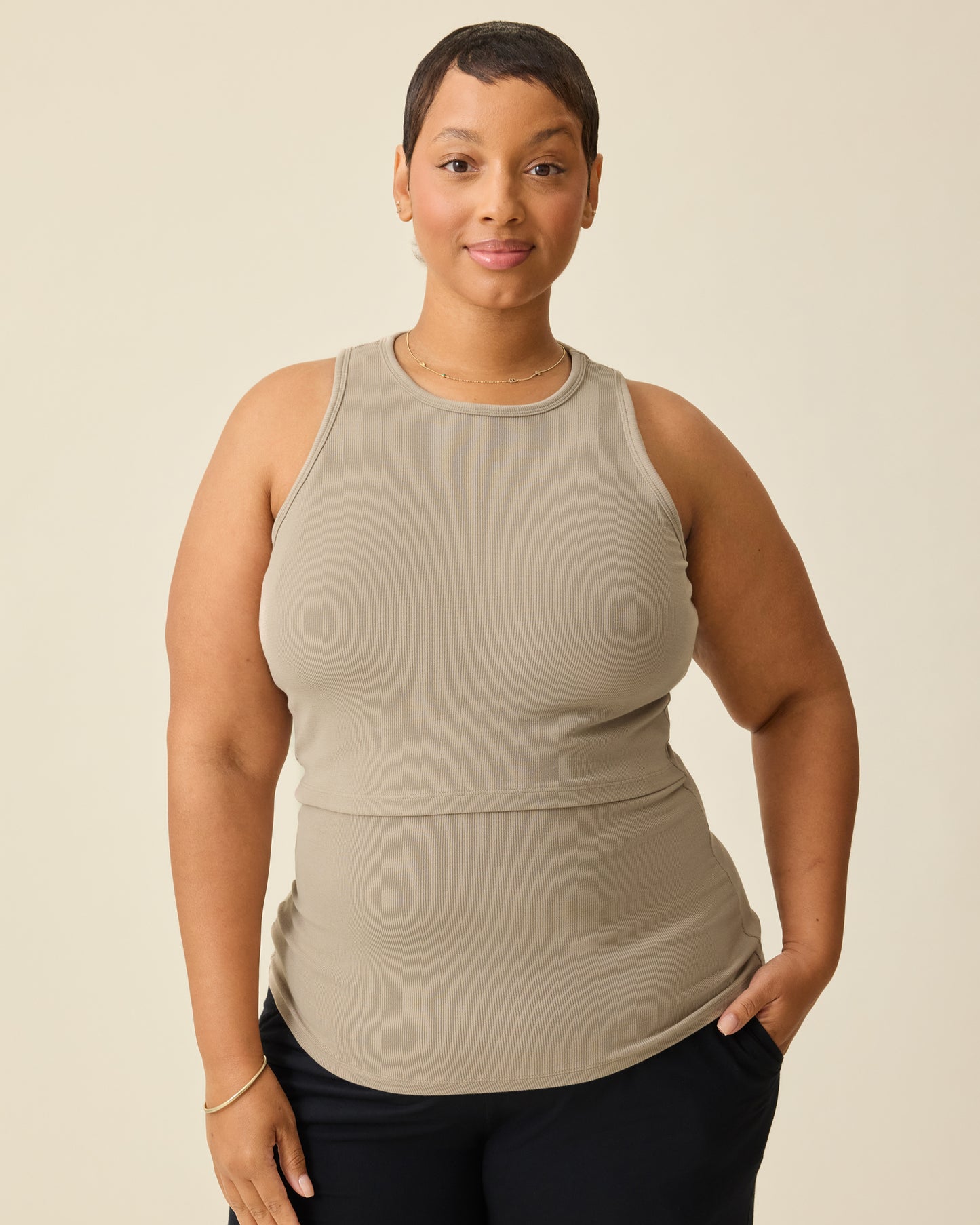 Model is wearing the Ribbed Bamboo Racerback Nursing Tank in Sandstone on a beige background. @model_info:Brittany is wearing an X-Large.