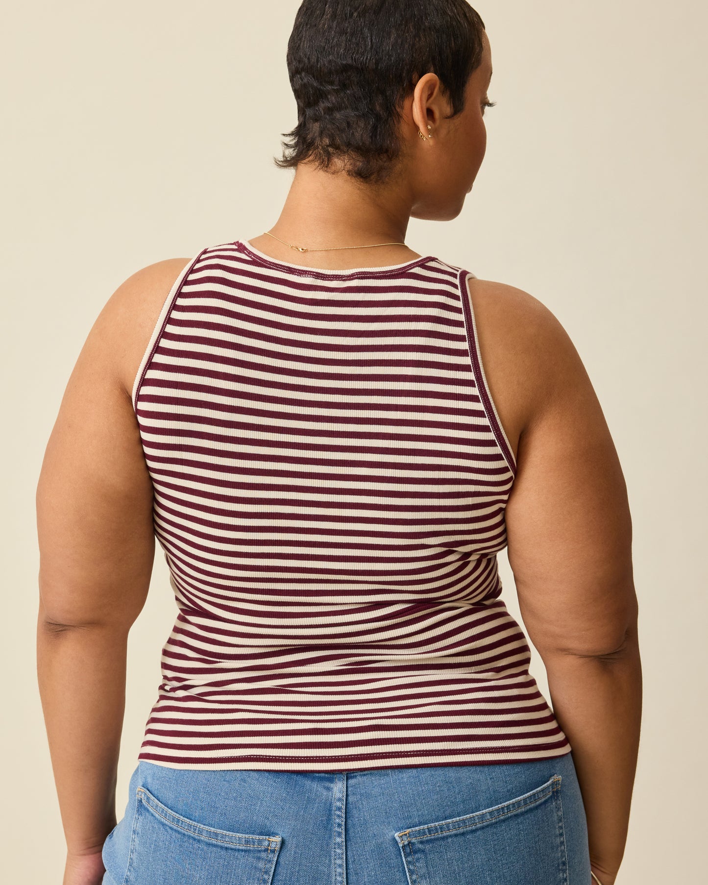 Back view of Ribbed Bamboo Scoop Neck Nursing Tank in Garnet Stripe on a beige background. 