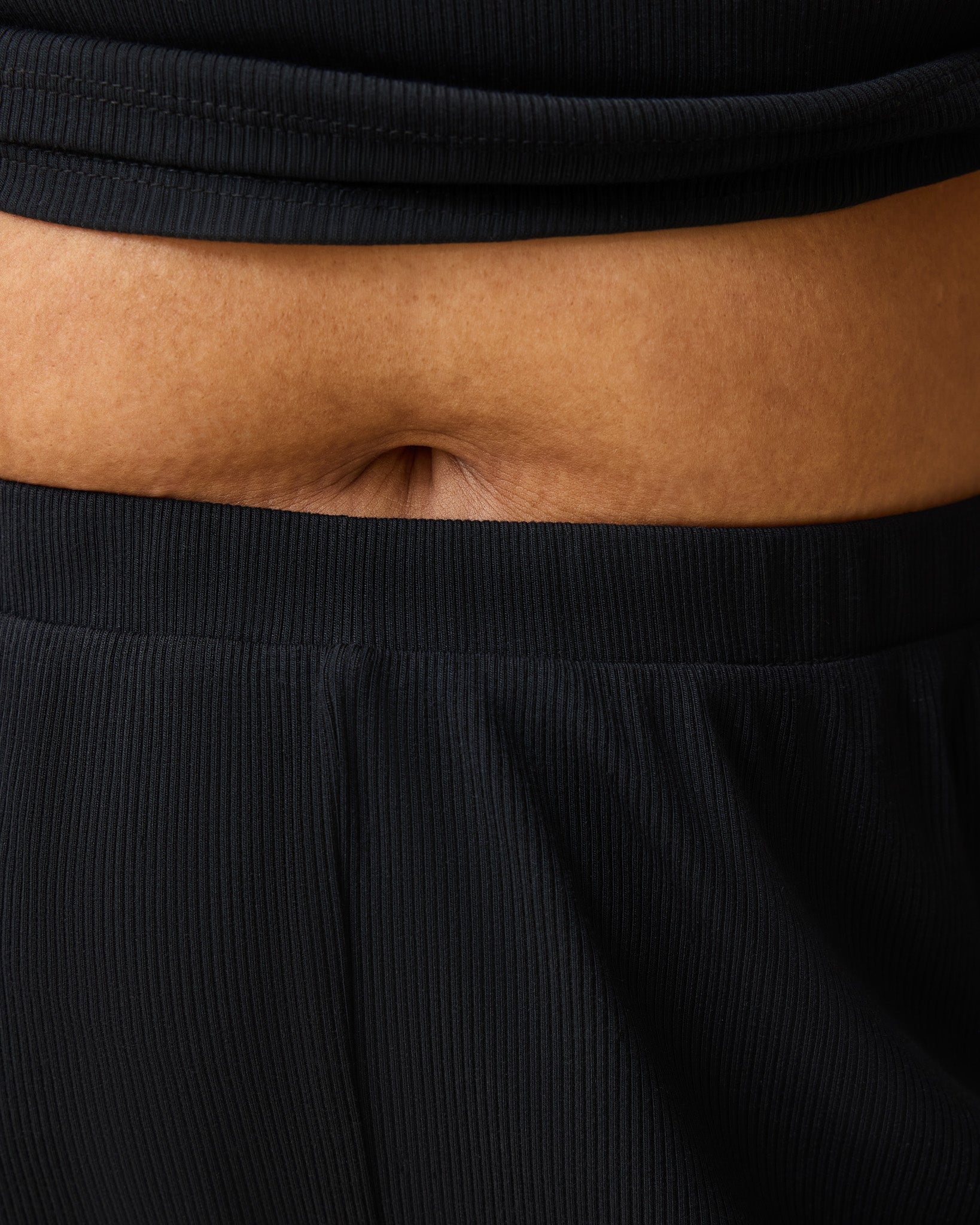 Close up on waist of model wearing Ribbed Modal Notched Nursing T-shirt in Black