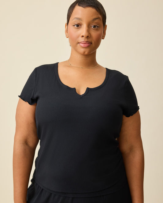 Model is wearing Ribbed Modal Notched Nursing T-shirt in Black on a beige background. @model_info:Brittany is wearing an XL.