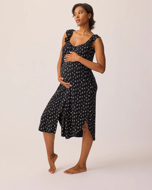 Model is wearing Ruffle Strap Labor & Delivery Gown in Black Wildflower on a beige background. @model_info:Ale is 5'9" and wearing a M/L.
