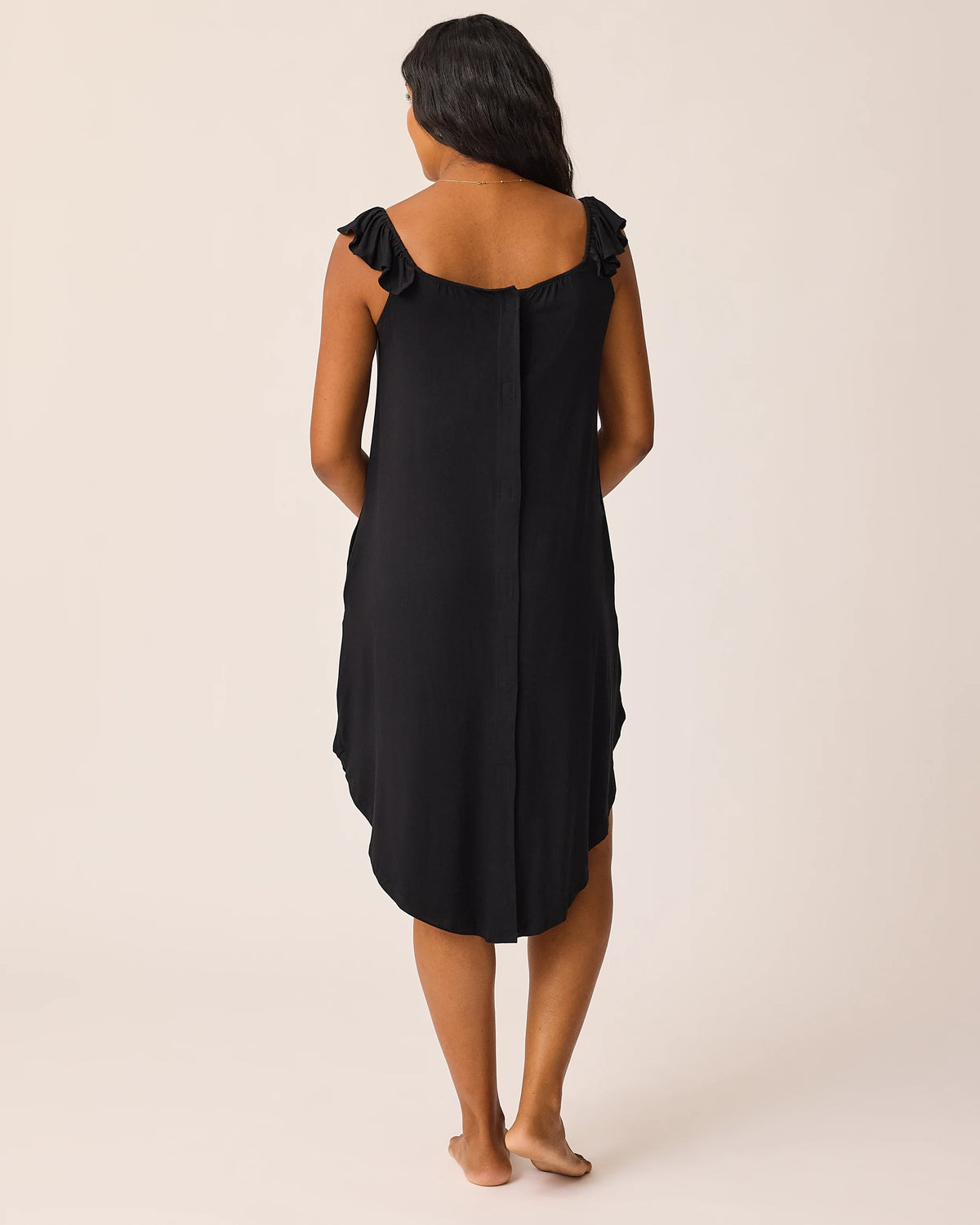 Woman wearing the Ruffle Labor & Delivery Gown in black, showing back of gown