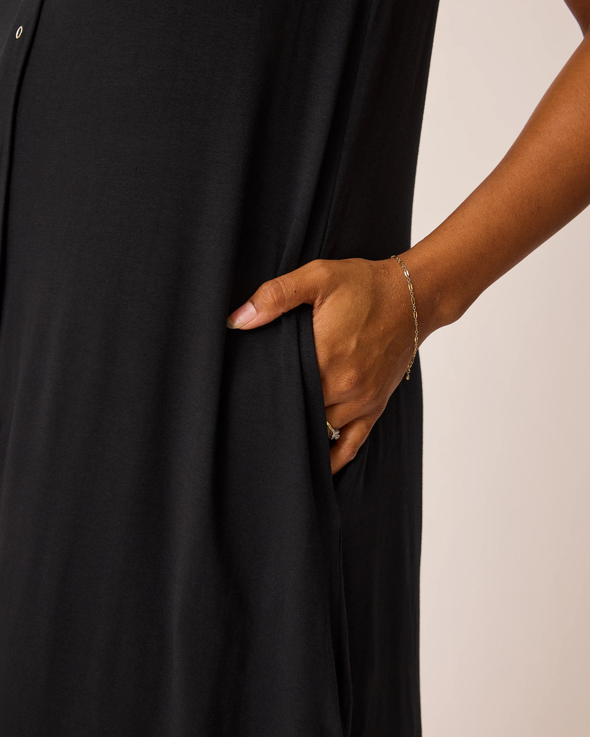 Close-up of woman wearing the Ruffle Labor & Delivery Gown in black, showing pocket detail