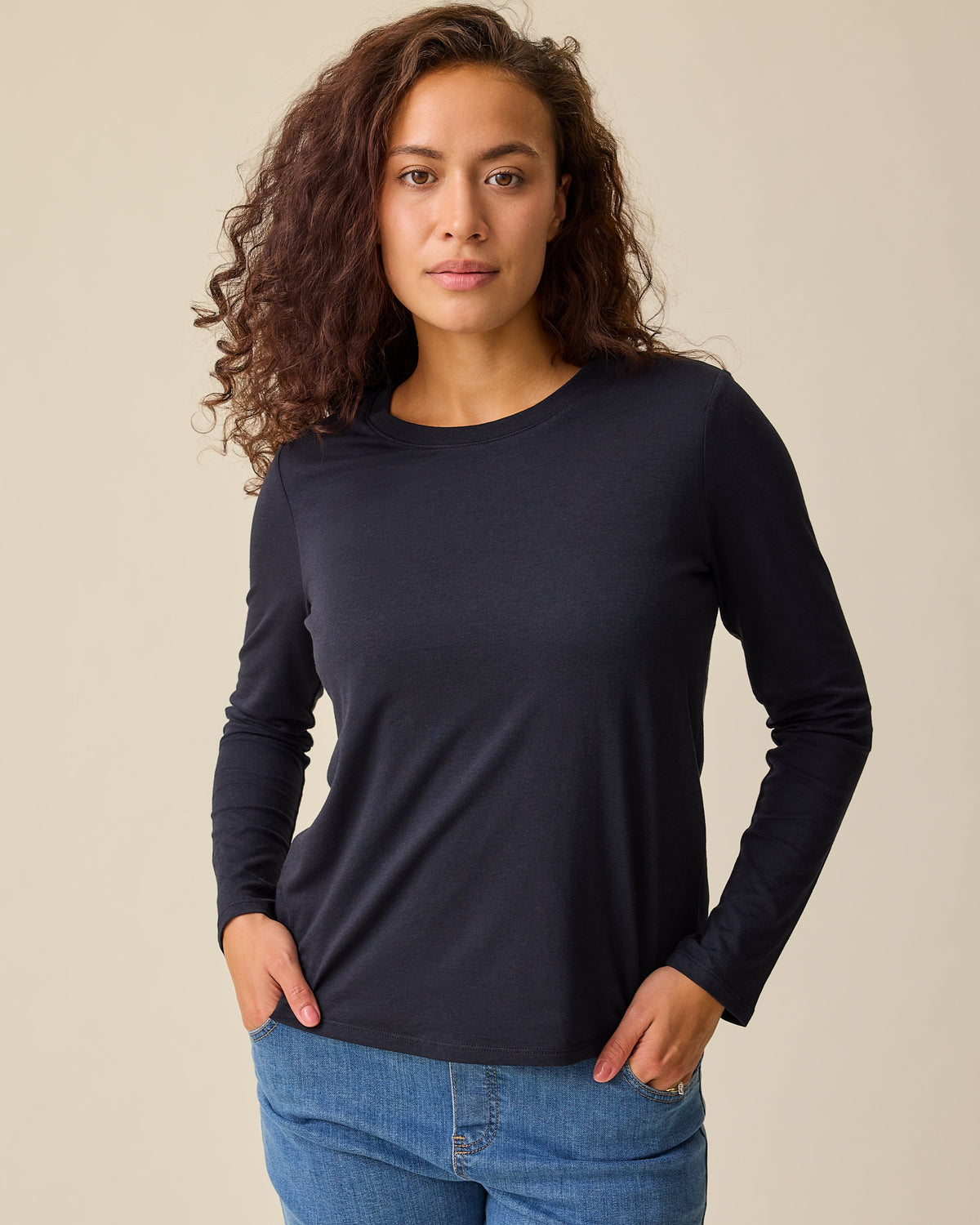 Model is wearing Modal Long Sleeve Nursing T-shirt in Black and Wide Leg Maternity & Postpartum Jean in Medium Wash on a beige background.@model_info:Sadie is wearing a Medium.