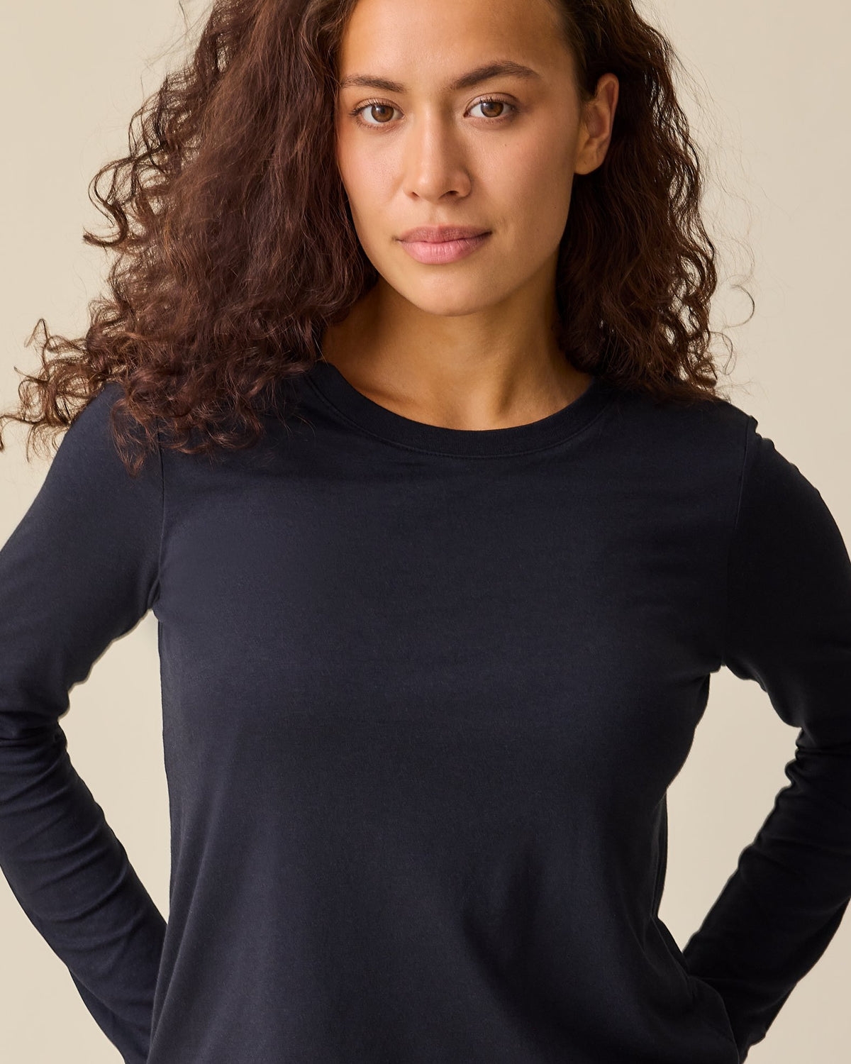 Model is wearing Modal Long Sleeve Nursing T-shirt in Black on a beige background.