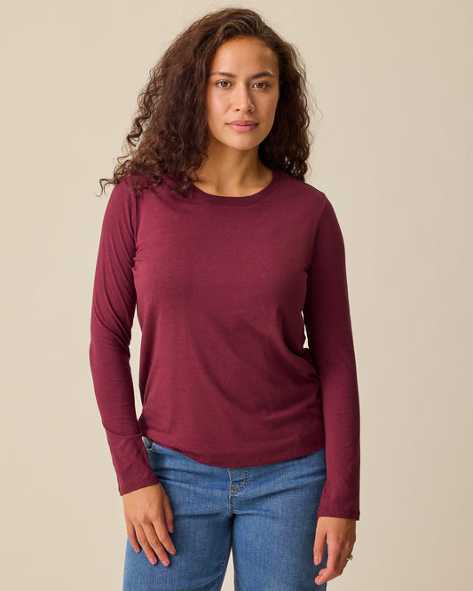 Model is wearing Modal Long Sleeve Nursing T-shirt in Garnet and Wide Leg Maternity & Postpartum Jean in Medium Wash on a beige background.@model_info:Sadie is wearing a Medium.