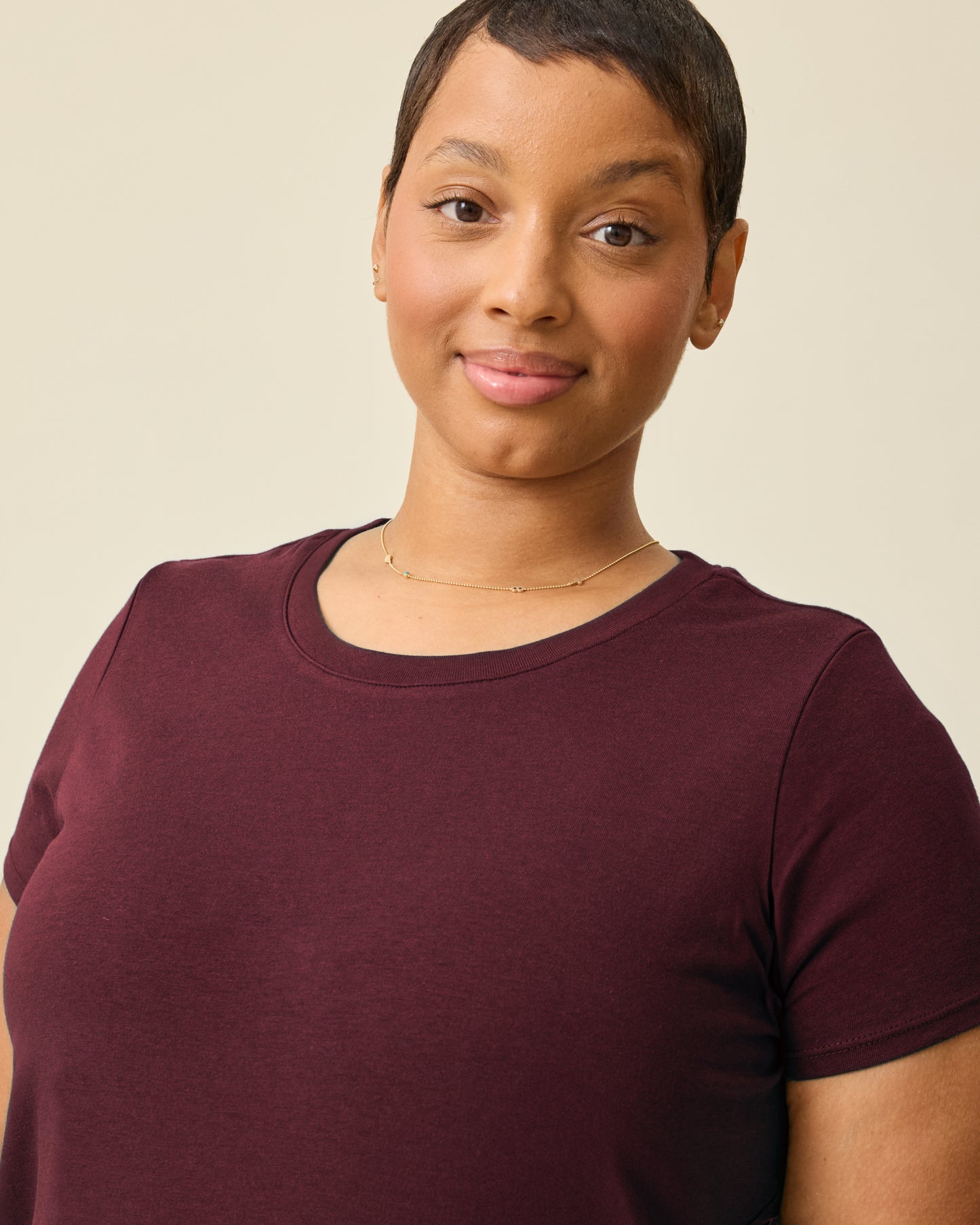 Model is wearing Modal Crew Neck Nursing T-shirt in Deep Burgundy on a beige background.