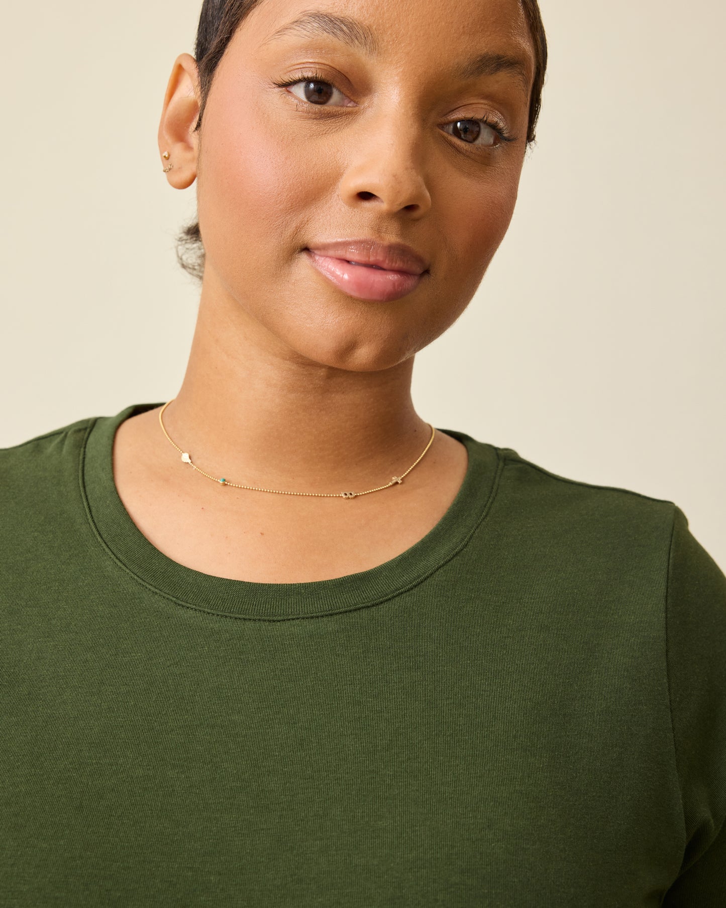 Model is wearing Modal Crew Neck Nursing T-shirt in Deep Olive, on a beige background.
