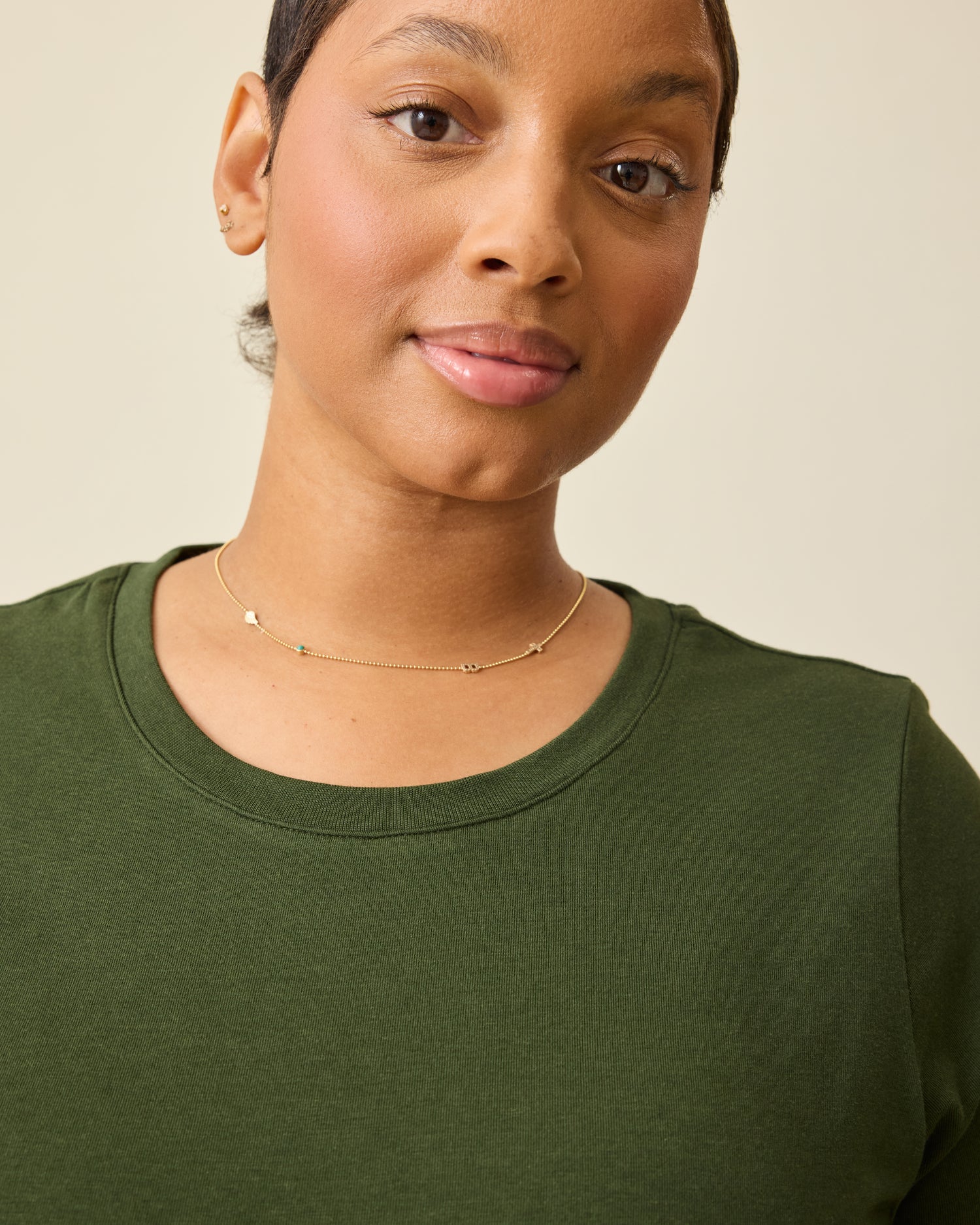 Model is wearing Modal Crew Neck Nursing T-shirt in Deep Olive, on a beige background.