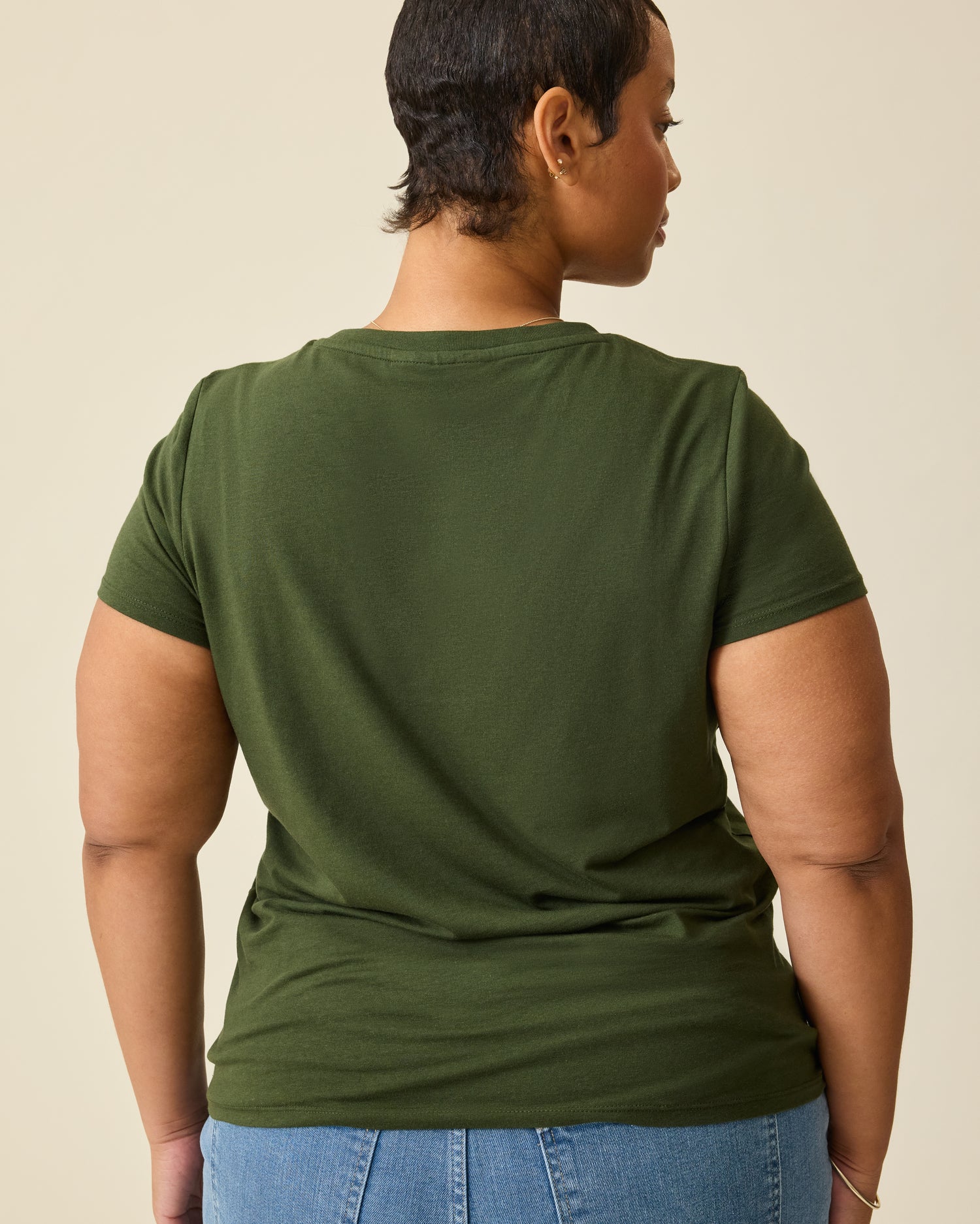 Back view on model wearing Modal Crew Neck Nursing T-shirt in Deep Olive, on a beige background.