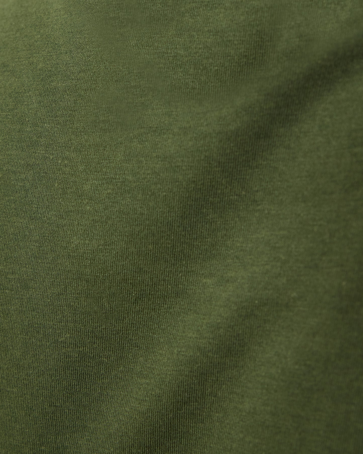 Close up of material of Modal Crew Neck Nursing T-shirt in Deep Olive, on a beige background.