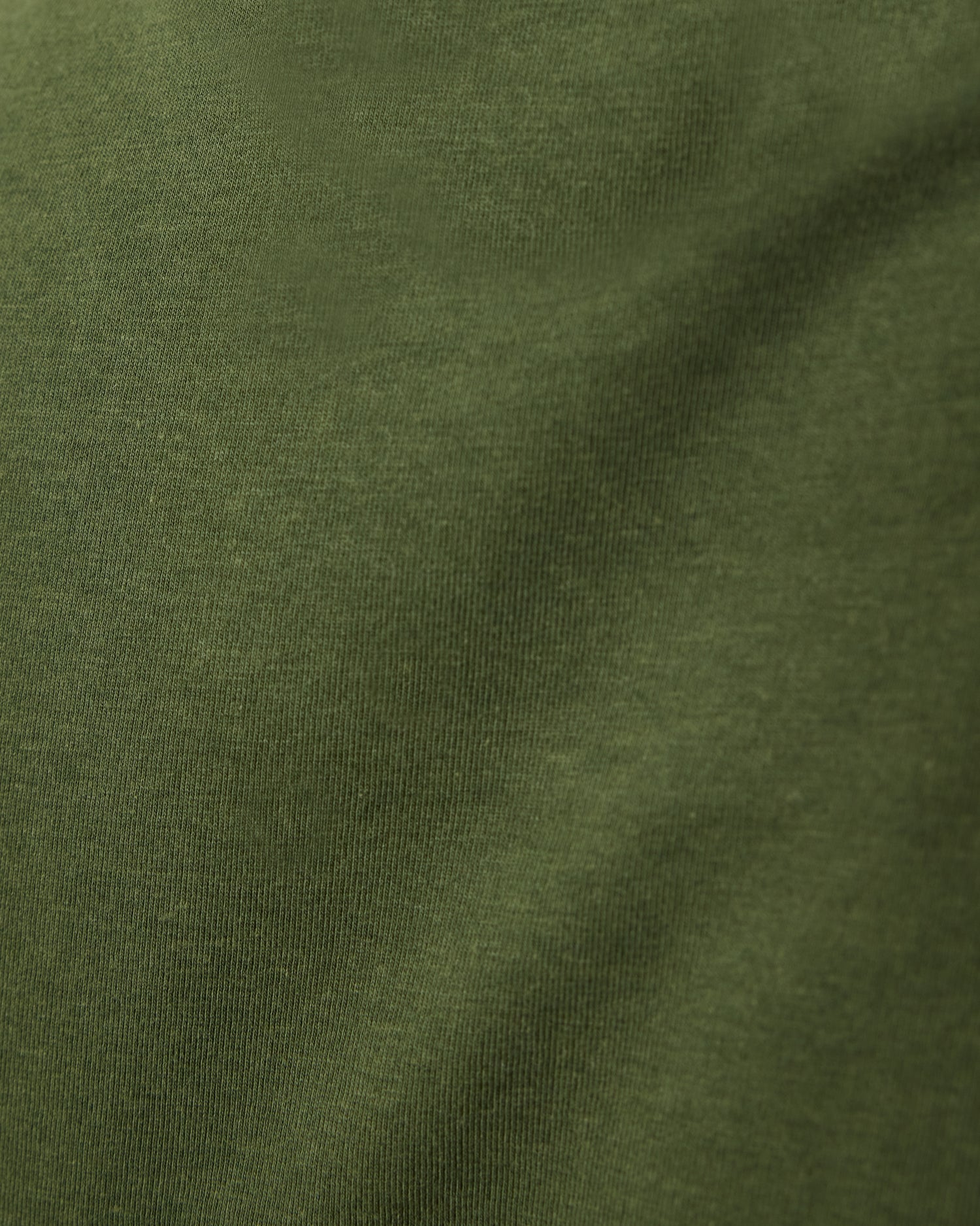 Close up of material of Modal Crew Neck Nursing T-shirt in Deep Olive, on a beige background.