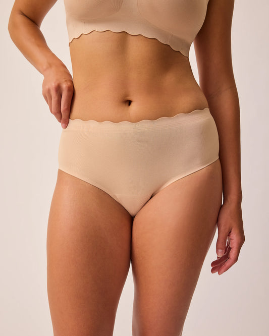 Model is wearing BareBond™ Cotton Maternity & Postpartum Brief in Sand and BareBond™ Cotton Maternity & Nursing Bra in Sand on a beige background.  @model_info:Sadie is wearing a Medium.