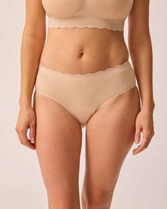 Close up of model wearing BareBond™ Cotton Maternity & Postpartum Hipster in Sand and BareBond™ Cotton Maternity & Nursing Plunge Bra in Sand on a beige background.  @model_info:KJ is wearing a Medium.