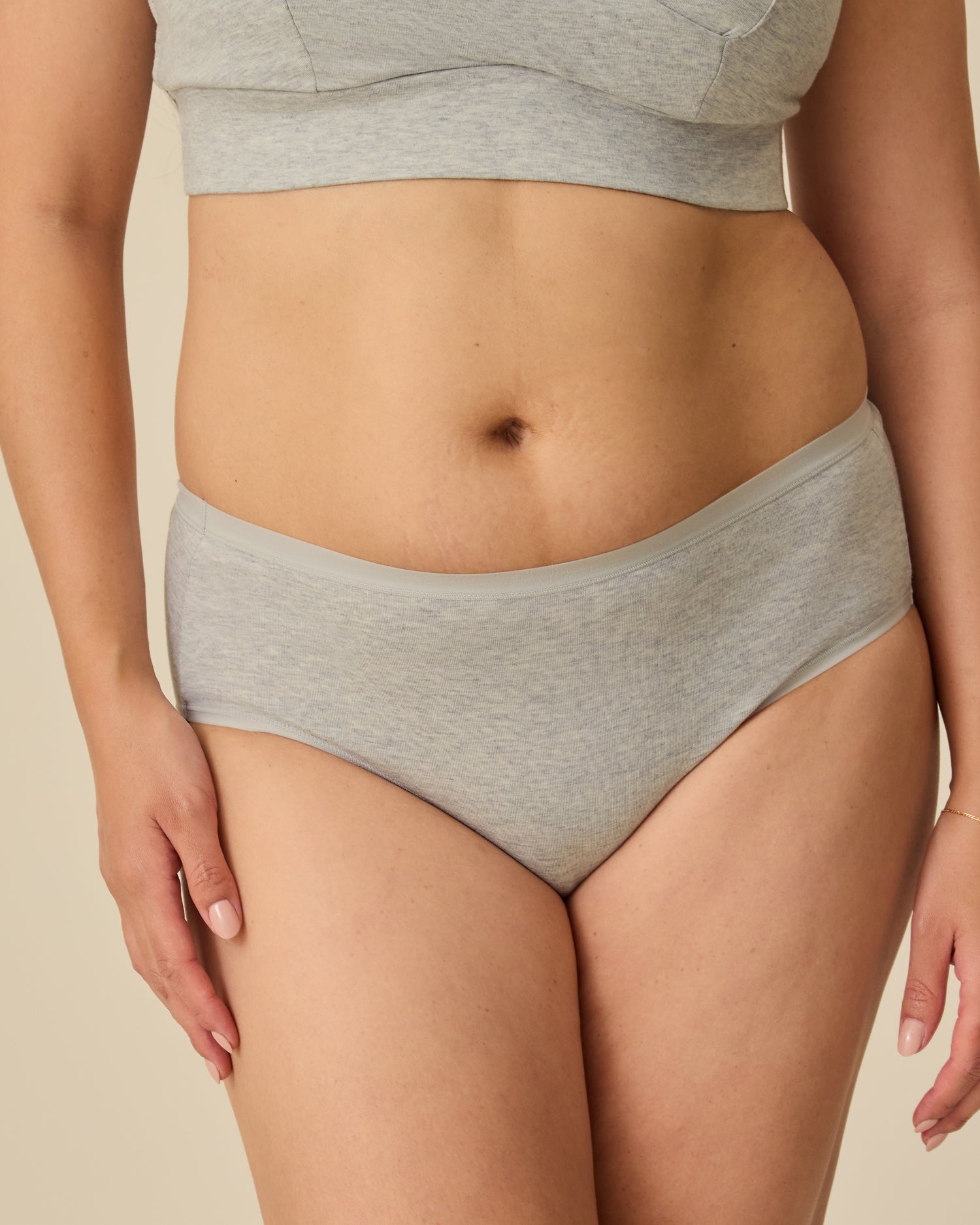 Model is wearing SoftStretch Cotton Nursing Bra in Grey Heather and SoftStretch Cotton Maternity & Postpartum Hipster in Grey Heather on a beige background. @model_info:Theresa is wearing a Small.