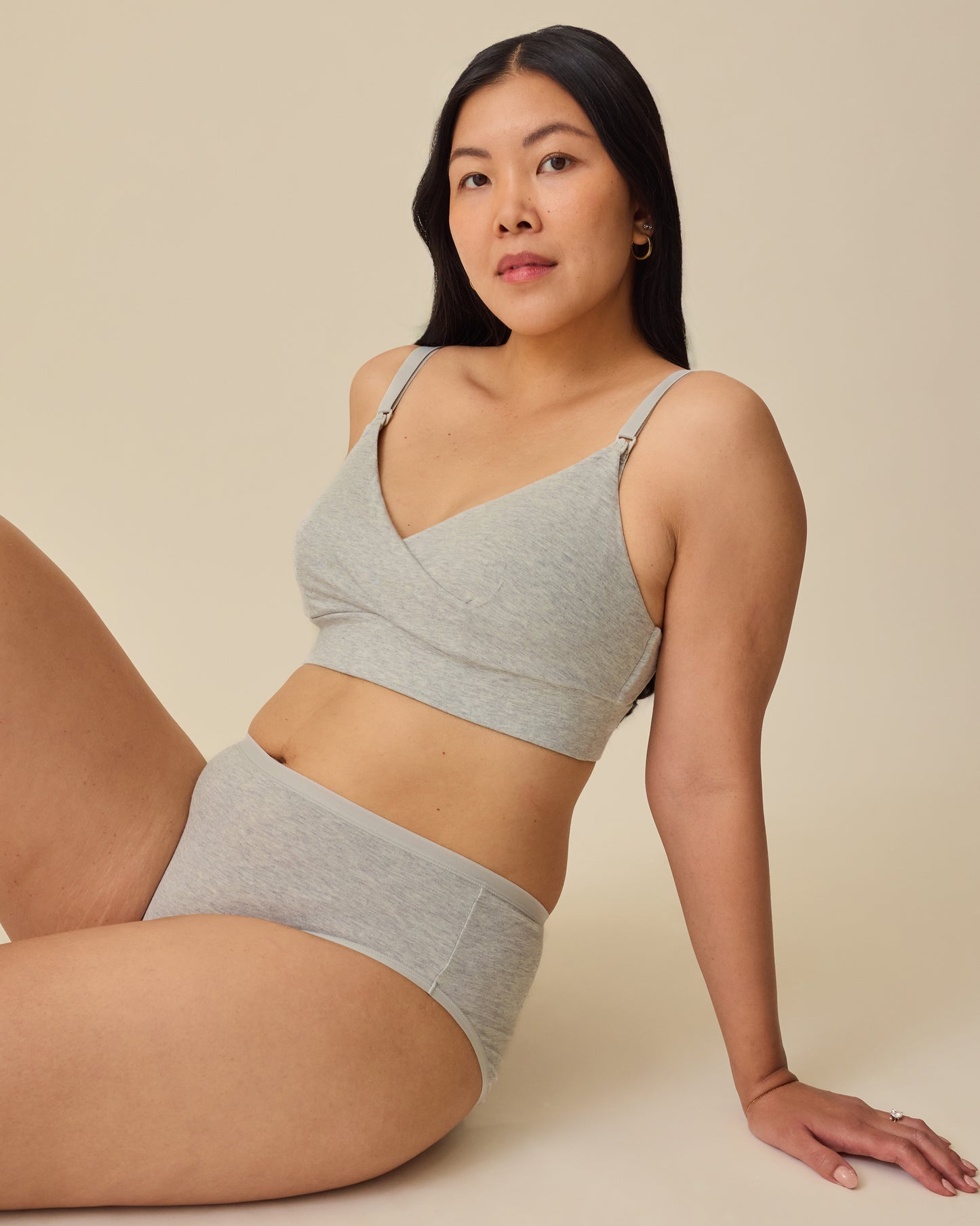 Model is lounging on floor while wearing SoftStretch Cotton Nursing Bra in Grey Heather and SoftStretch Cotton Maternity & Postpartum Brief in Grey Heather on a beige background. 