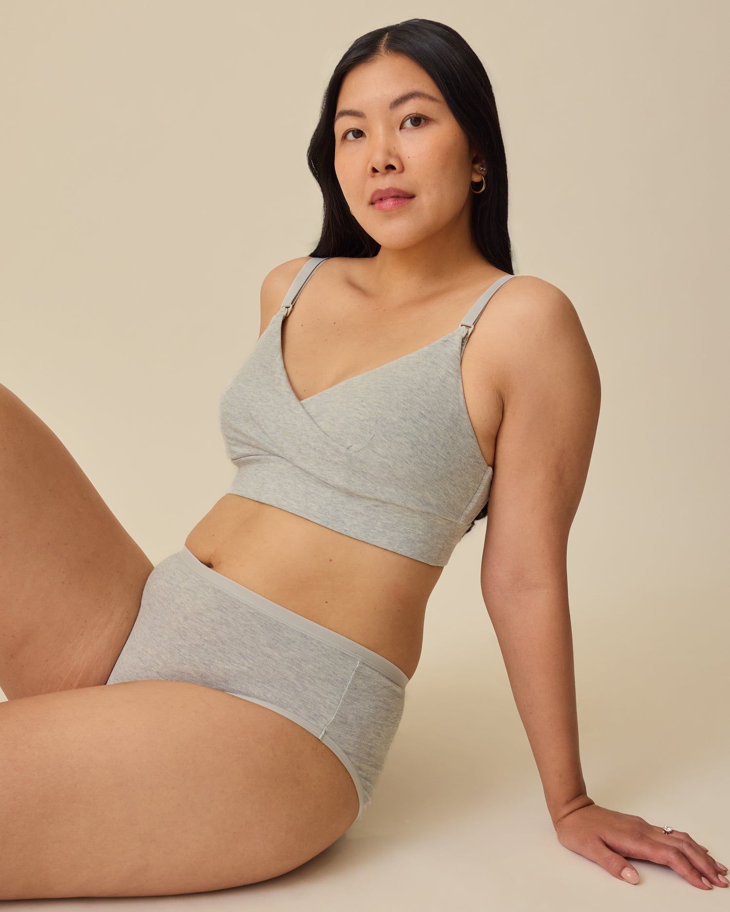 Model is lounging on floor while wearing SoftStretch Cotton Nursing Bra in Grey Heather and SoftStretch Cotton Maternity & Postpartum Brief in Grey Heather on a beige background. 