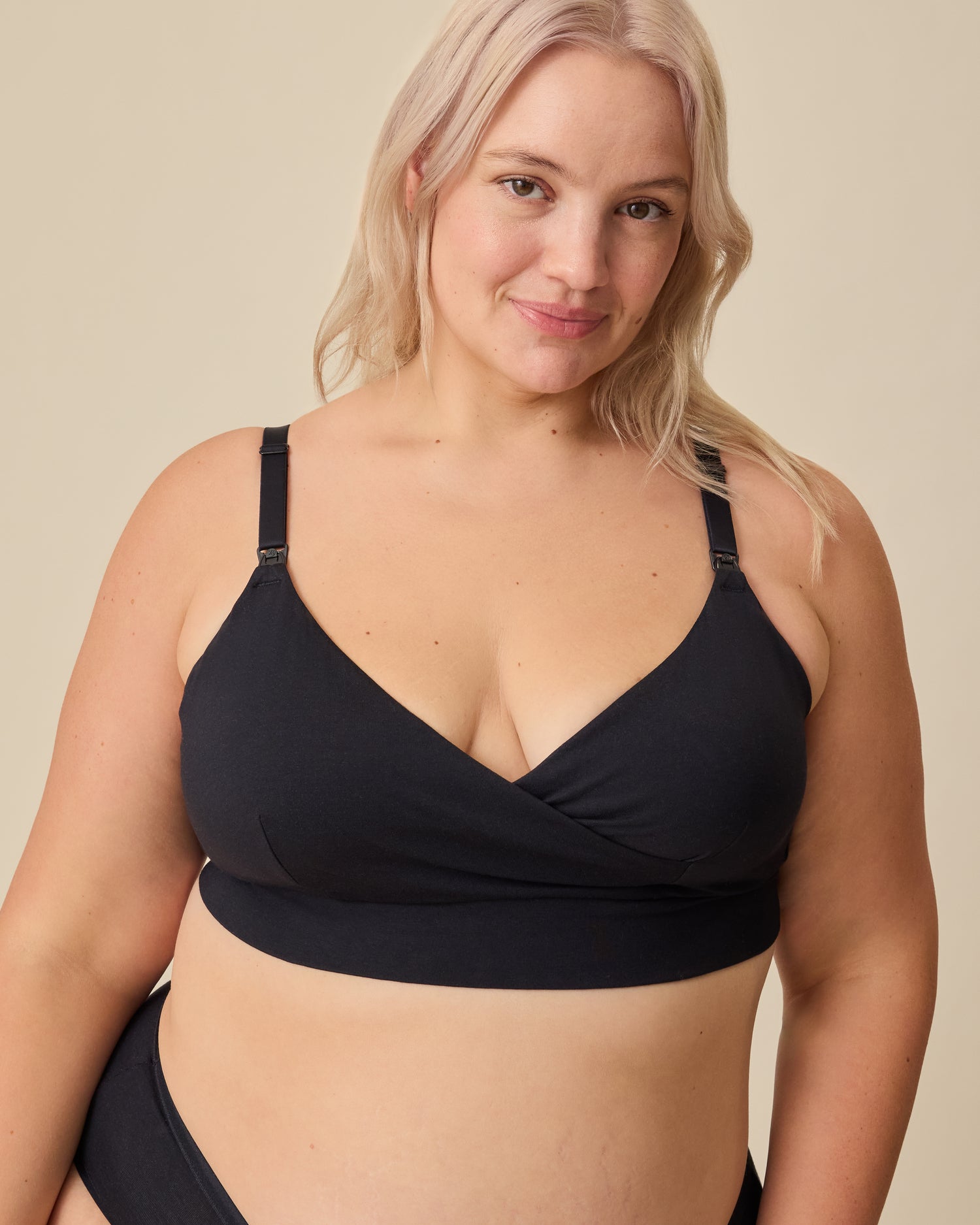 Model is wearing SoftStretch Cotton Nursing Bra and SoftStretch Cotton Maternity & Postpartum Hipster in Black on a beige background. 
@model_info:Allie is wearing an X-Large.