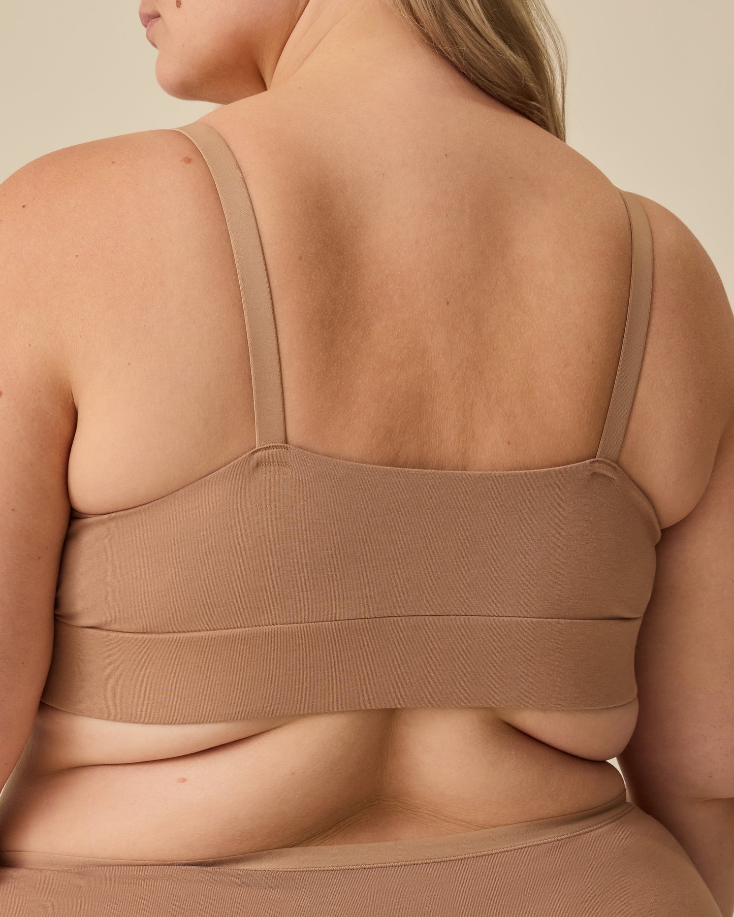 Back view of model wearing SoftStretch Cotton Nursing Bra and SoftStretch Cotton Maternity & Postpartum Brief in Buff on a beige background.