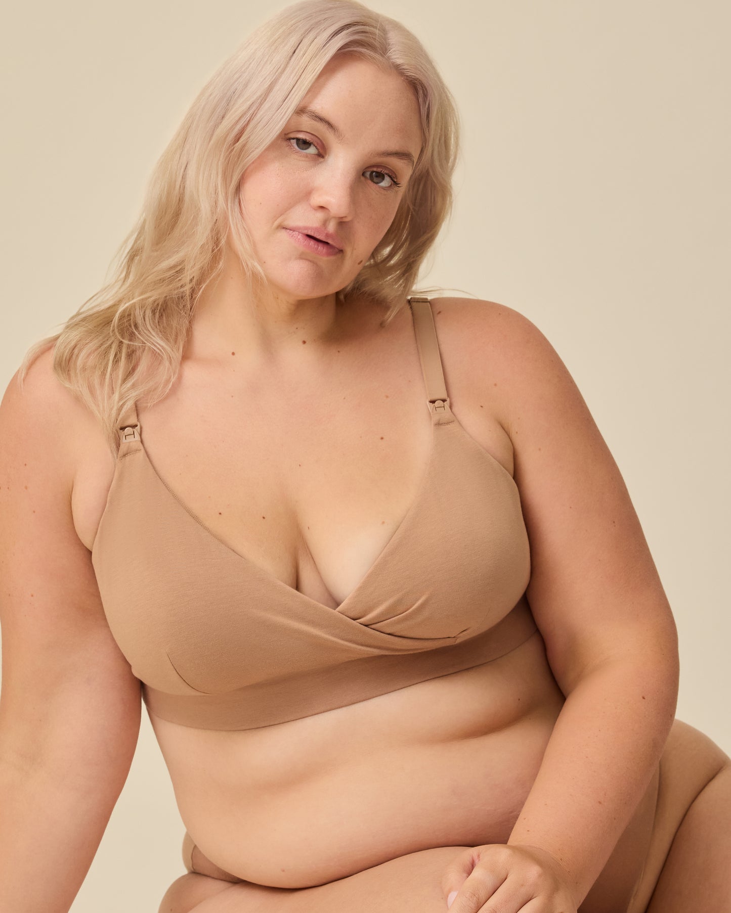 Model is wearing SoftStretch Cotton Nursing Bra in Buff on a beige background.