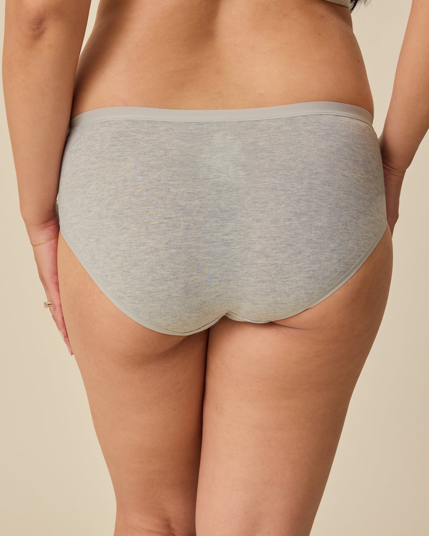 Back view of SoftStretch Cotton Maternity & Postpartum Hipster in Grey Heather on a beige background. 