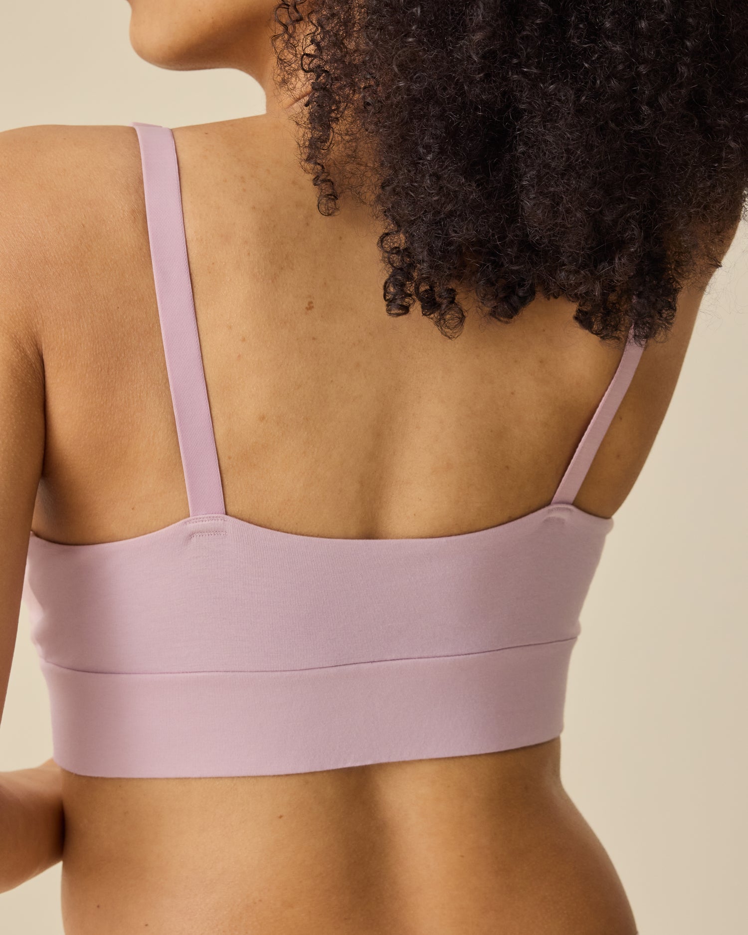 Back view of model wearing SoftStretch Cotton Maternity & Nursing Bralette in Lilac Mist on a beige background.
