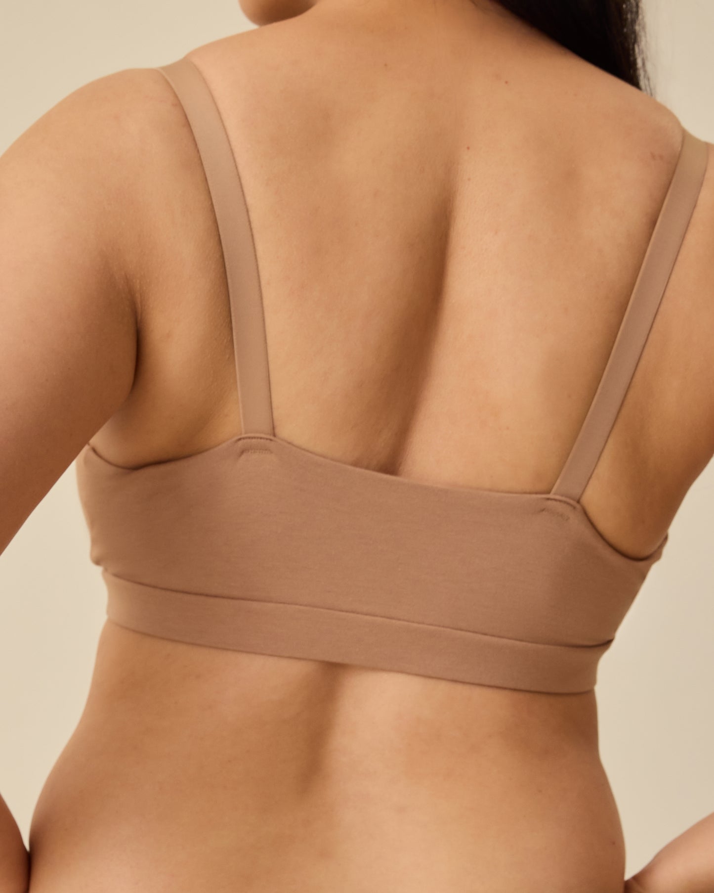 Back view of the SoftStretch Cotton Maternity & Nursing Bralette in Buff, on a beige background.