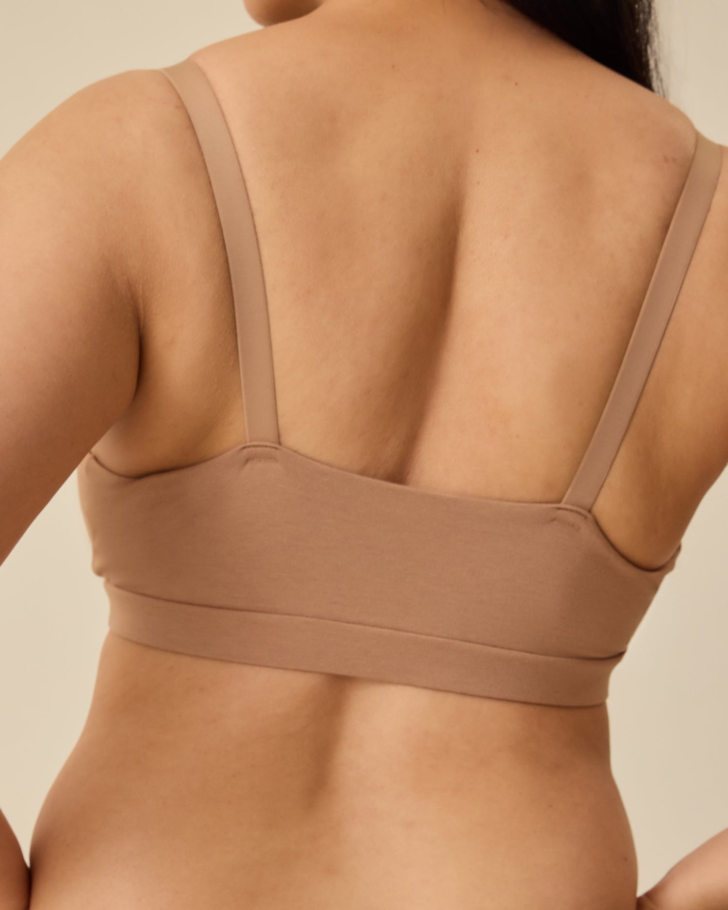 Back view of the SoftStretch Cotton Maternity & Nursing Bralette in Buff, on a beige background.
