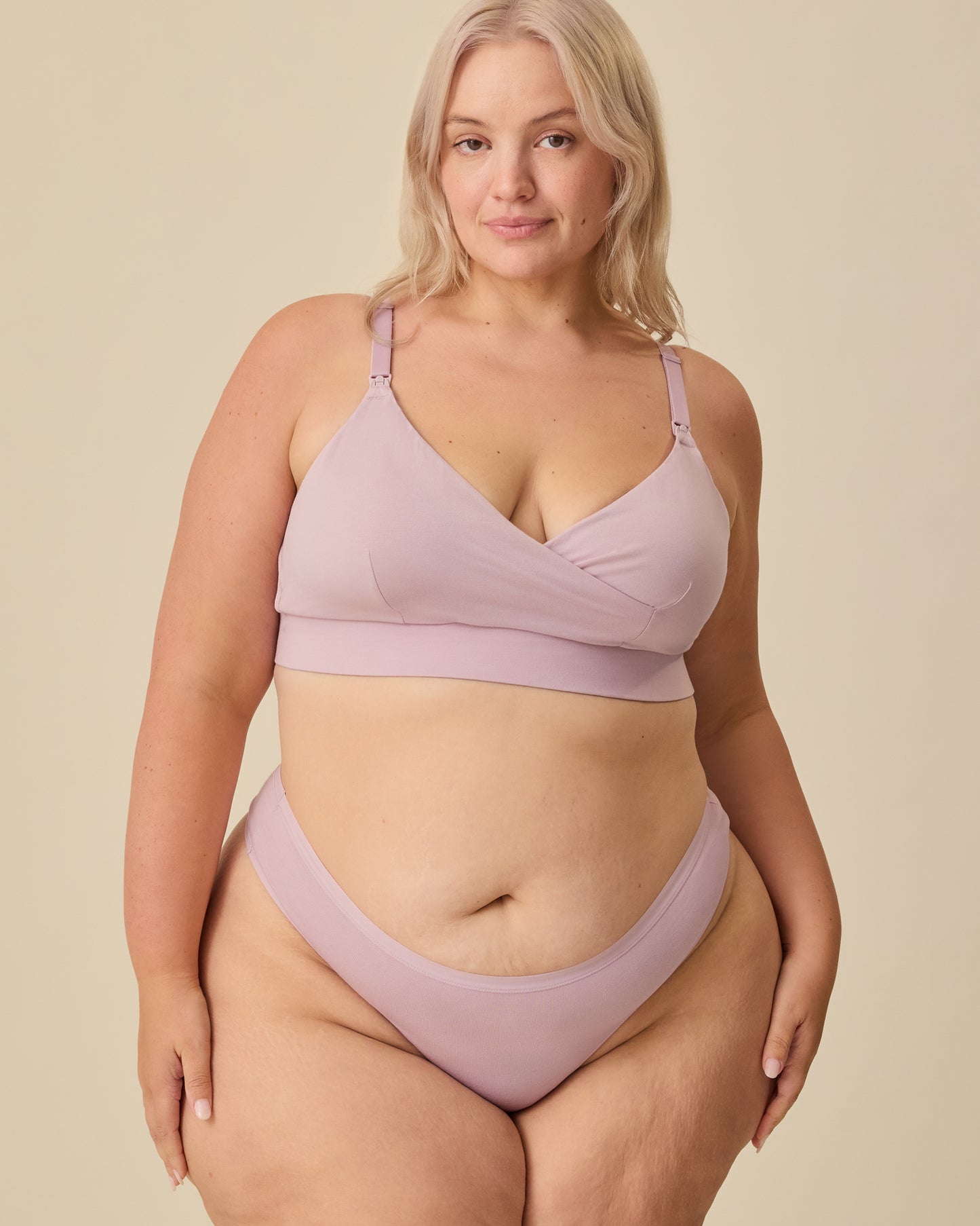 Model is wearing SoftStretch Cotton Nursing Bra in Lilac Mist and SoftStretch Cotton Maternity & Postpartum Thong in Lilac Mist on a beige background.