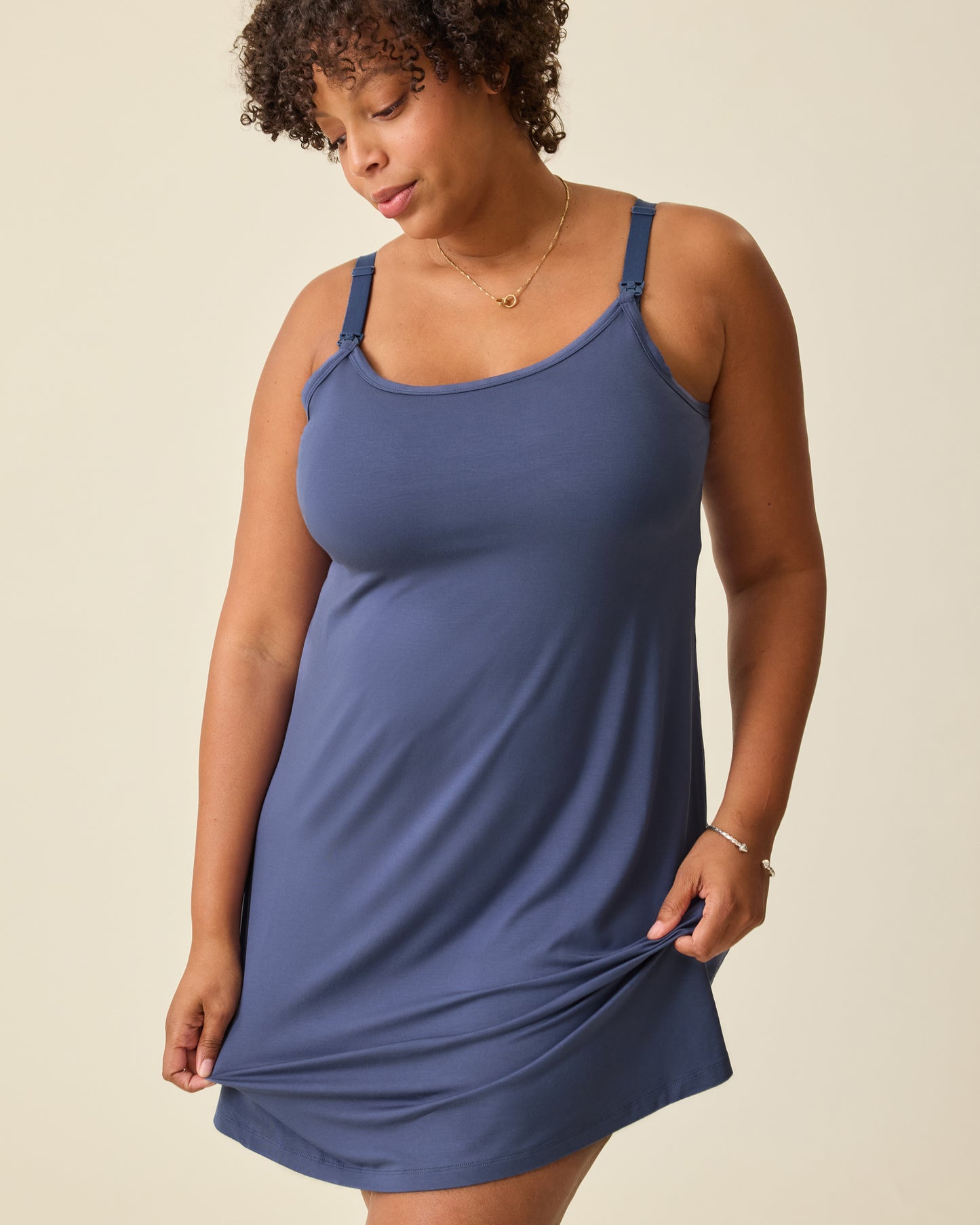 Model is wearing Stella Hands-Free Pumping & Nursing Nightgown in Slate Blue, on a beige background.