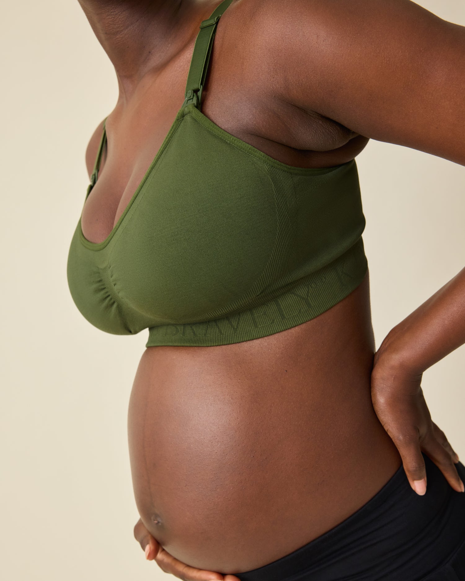 Side view of Simply Sublime® Nursing Bra in Deep Olive on a beige background. 