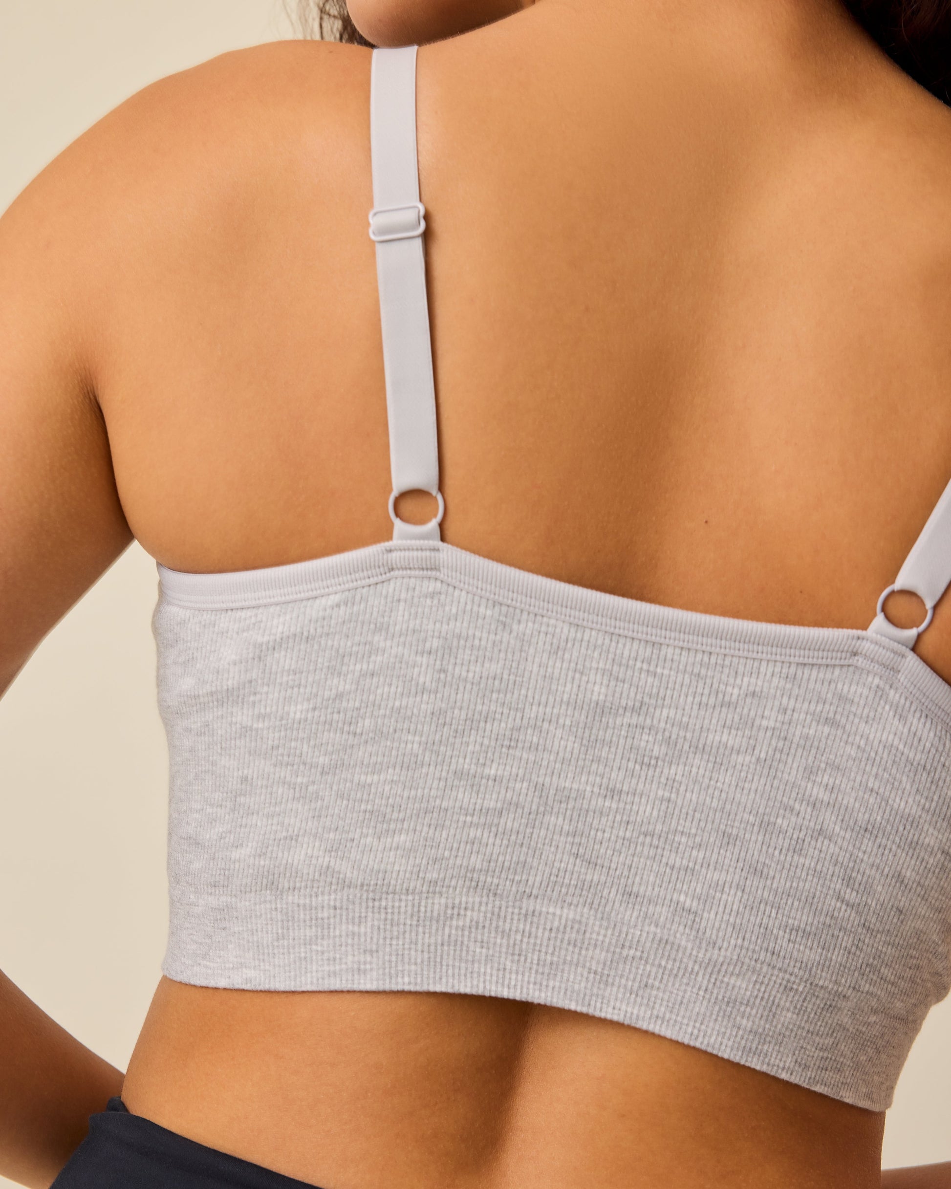 Back view of the model wearing Sublime® Bamboo Hands-Free Pumping Lounge & Sleep Bra in Grey Heather, on a beige background.