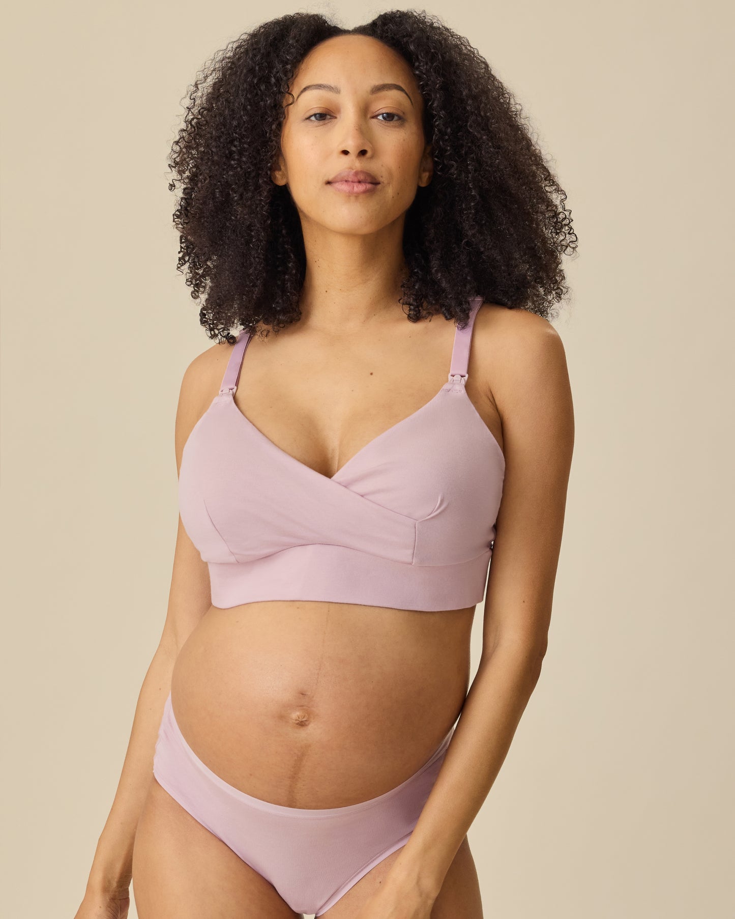 Pregnant model wearing SoftStretch Cotton Nursing Bra and SoftStretch Cotton Maternity & Postpartum Brief in Lilac Mist on a beige background.