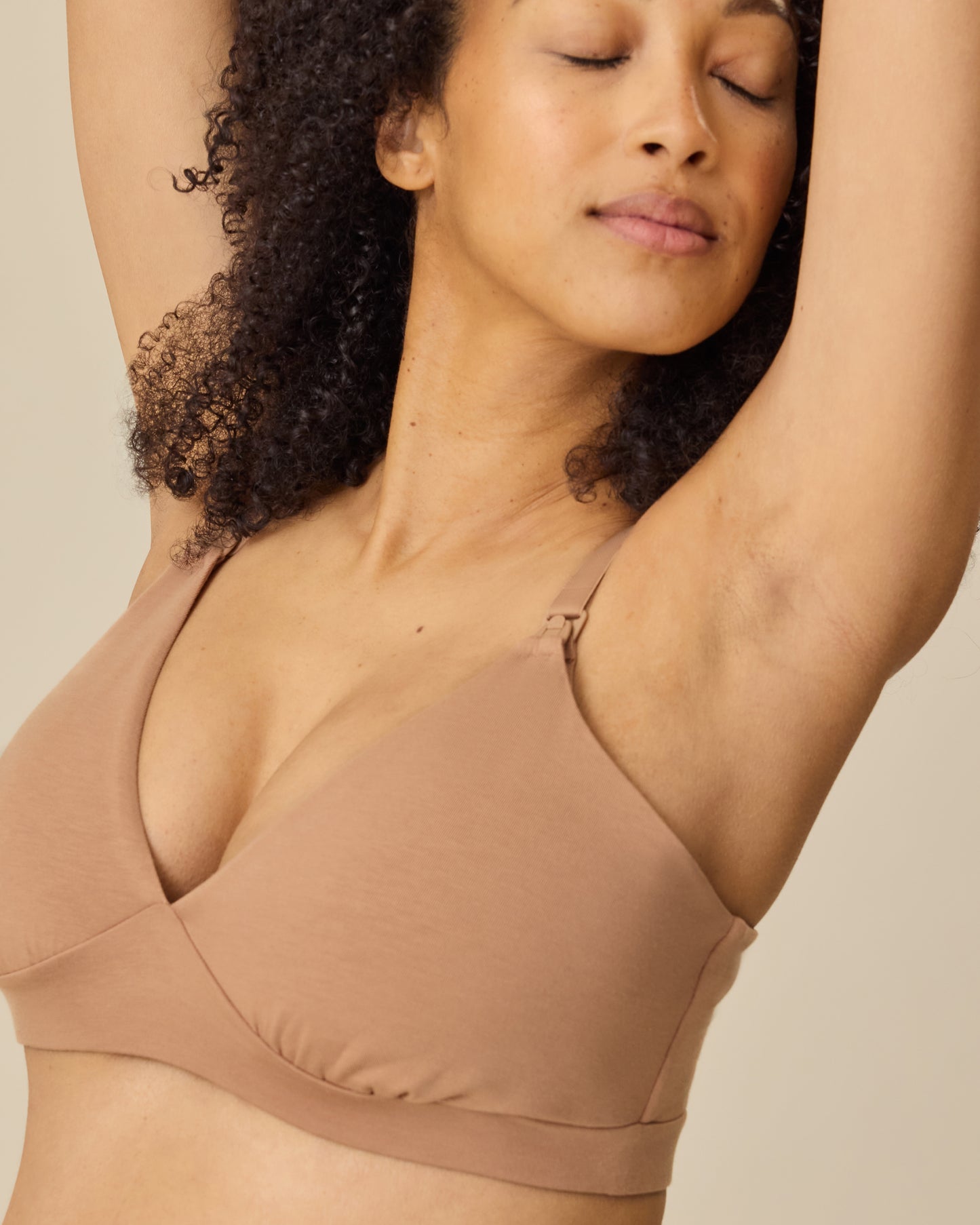 Model is wearing SoftStretch Cotton Maternity & Nursing Bralette in Buff on a beige background.