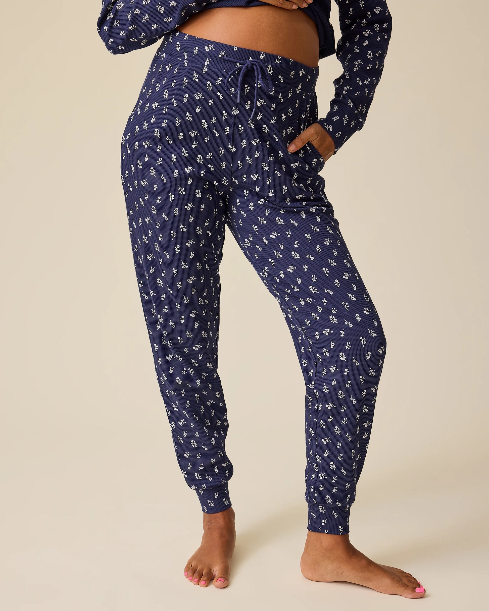 Close up on pants of Waffle Maternity & Nursing Lounge Set in Navy Wildflower on a beige background.