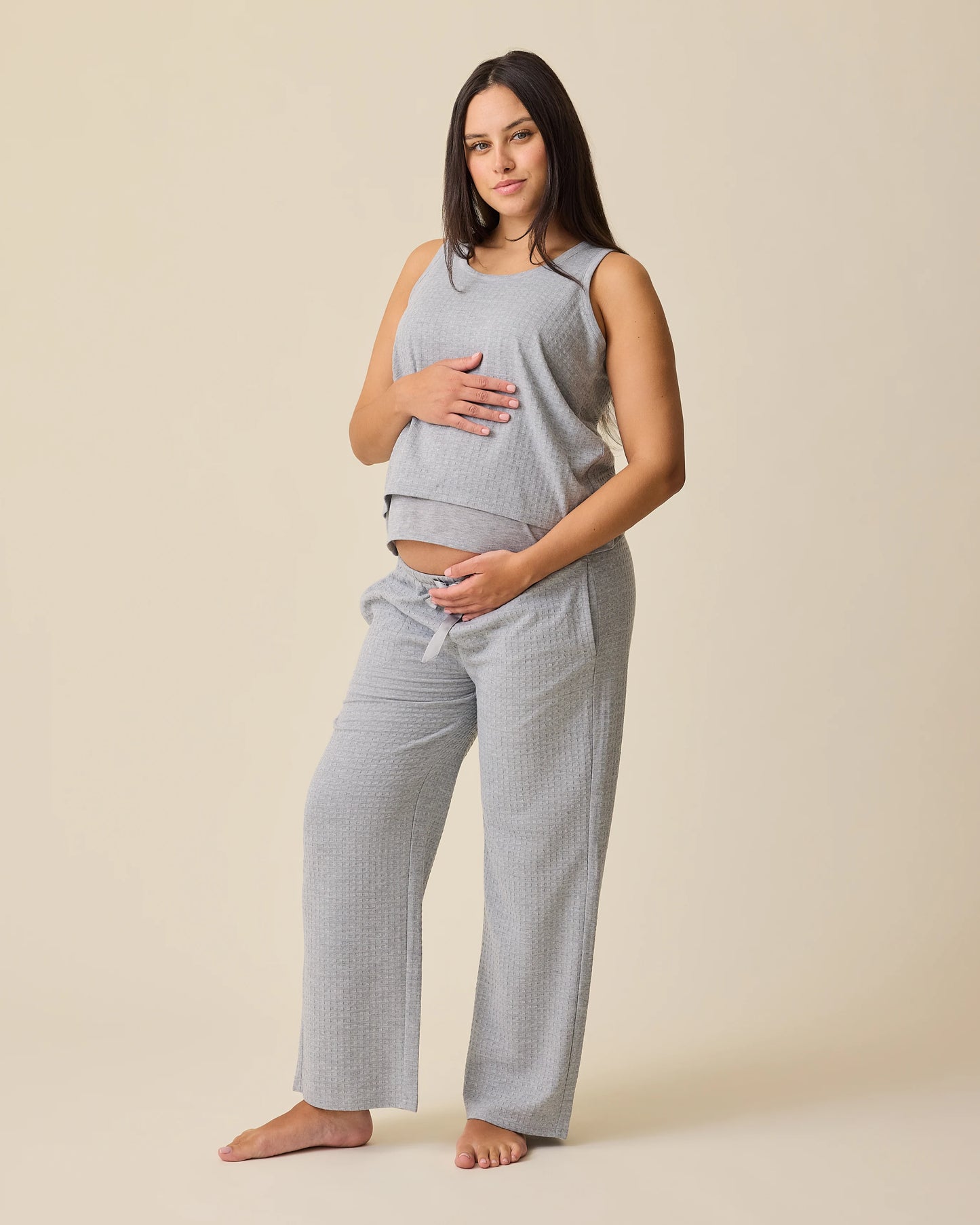 Model is wearing two of the three pieces of the Waffle Maternity & Nursing Three-Piece Lounge Set in Grey Heather on a beige background.