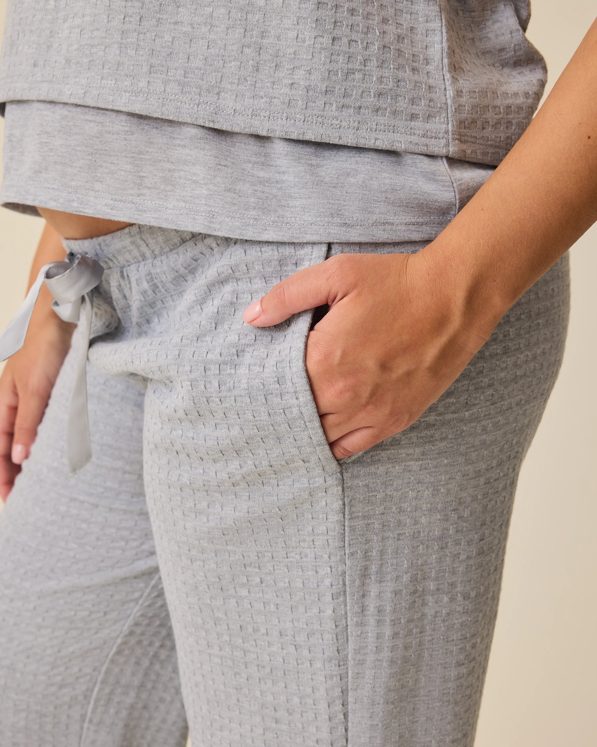Close up of pocket on the Waffle Maternity & Nursing Three-Piece Lounge Set in Grey Heather on a beige background.