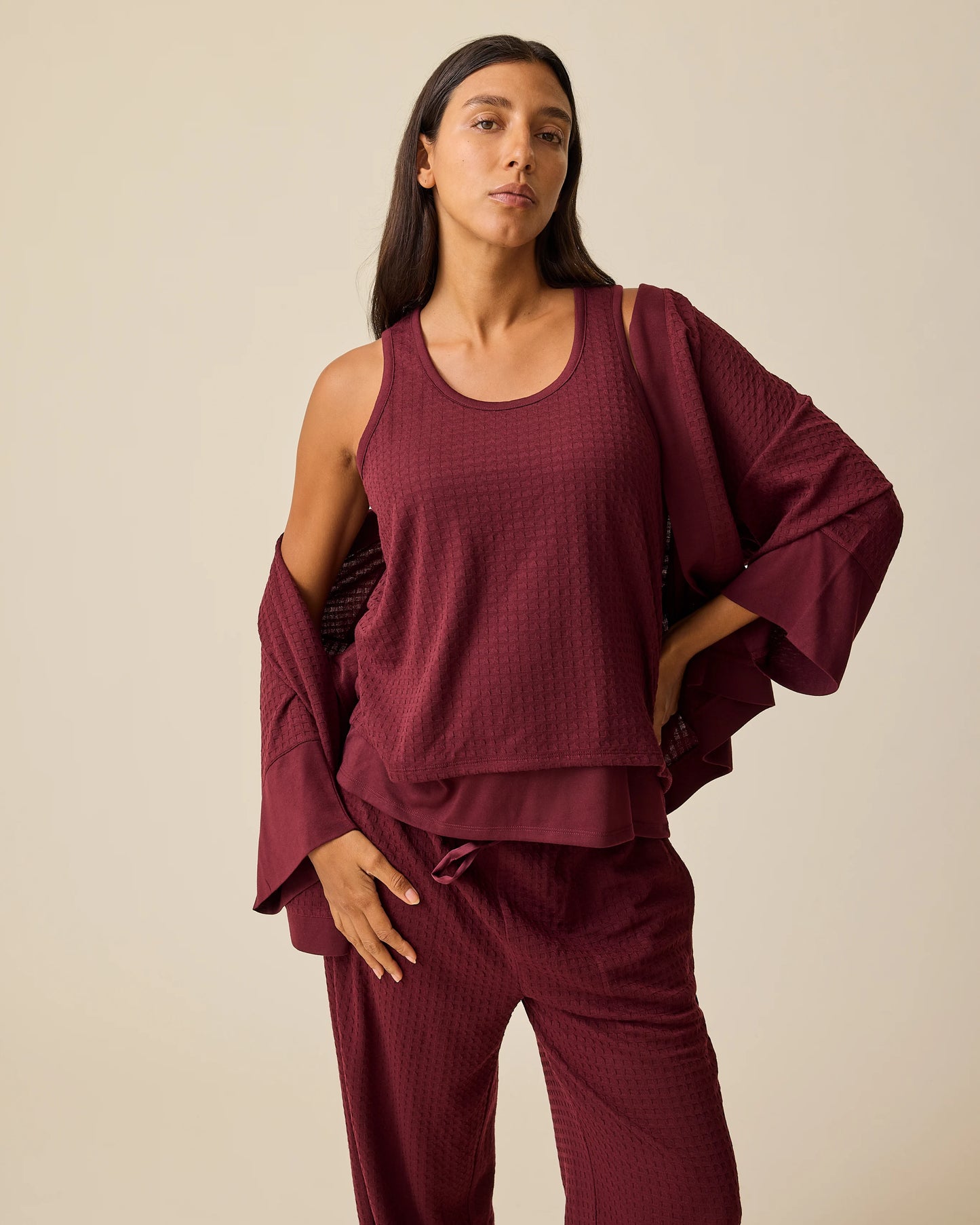 Model is wearing Waffle Maternity & Nursing Three-Piece Lounge Set in Garnet on a beige background.